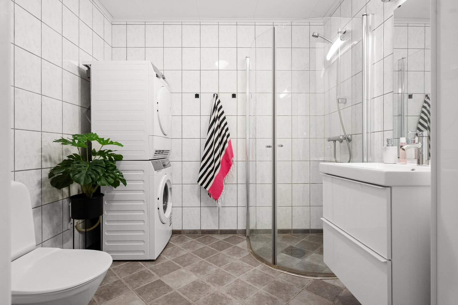 Badet er fra byggeår med fliser på gulv og vegger. Oppvarming via varmekabler. Galleribilde