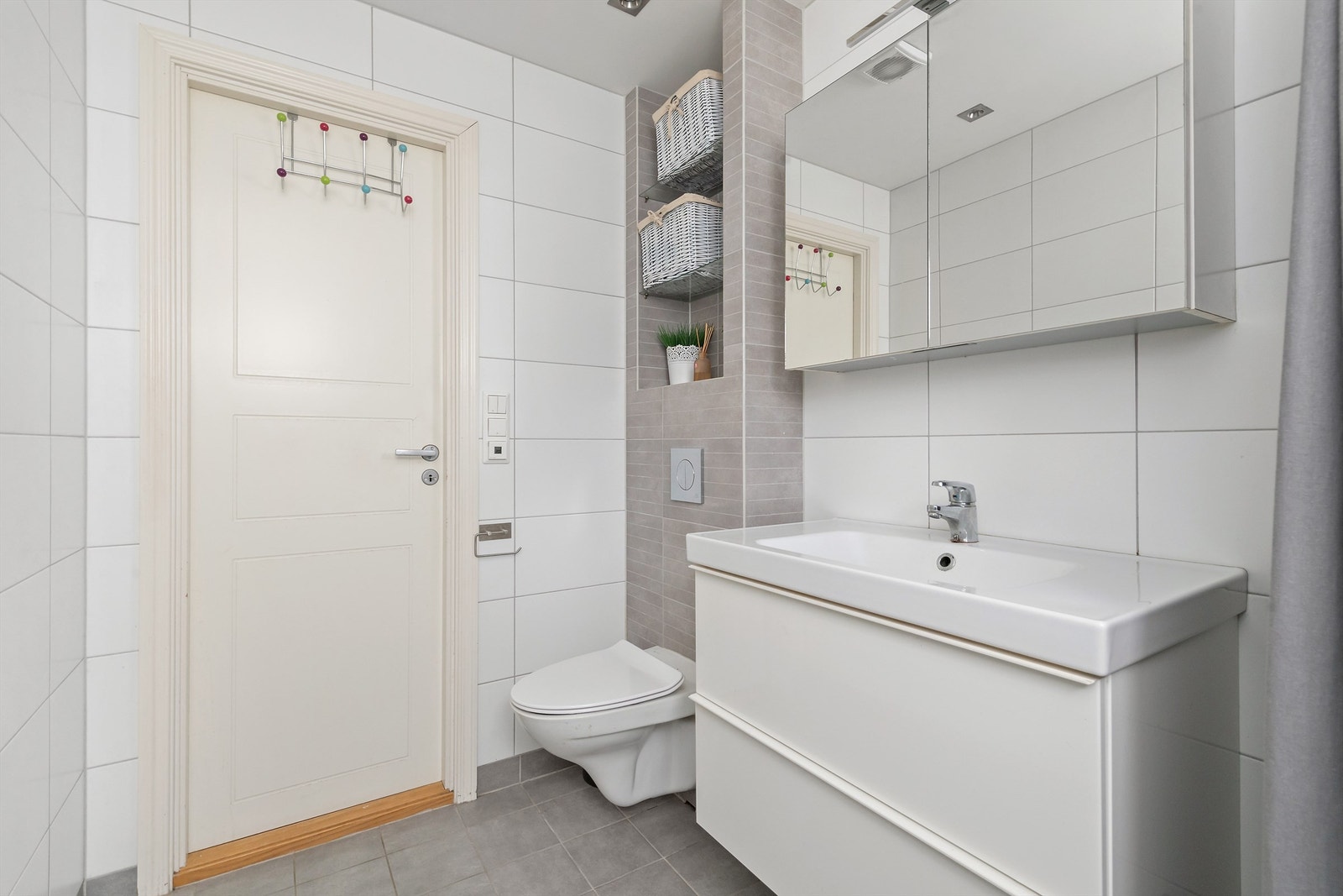 Badet er innredet med vegghengt toalett, baderomsinnredning og dusjhjørne med forheng Galleribilde