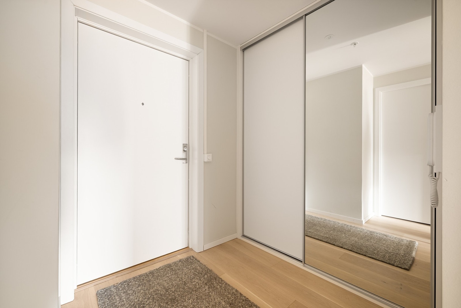 Innbydende entré med en praktisk skyvedørsgarderobe som gir god plass til å henge fra seg yttertøy. Galleribilde