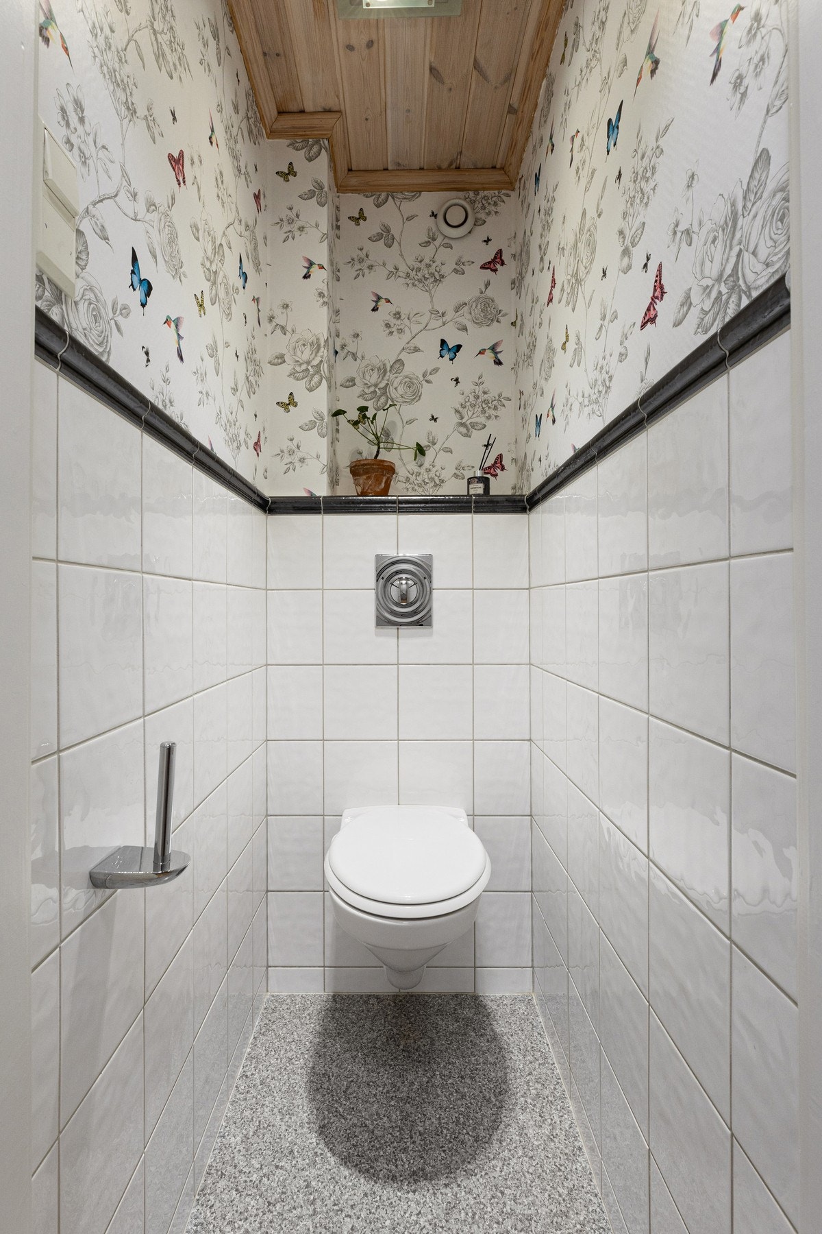 Vegg i vegg med badet ligger et toalettrom, innredet med vegghengt toalett. Galleribilde