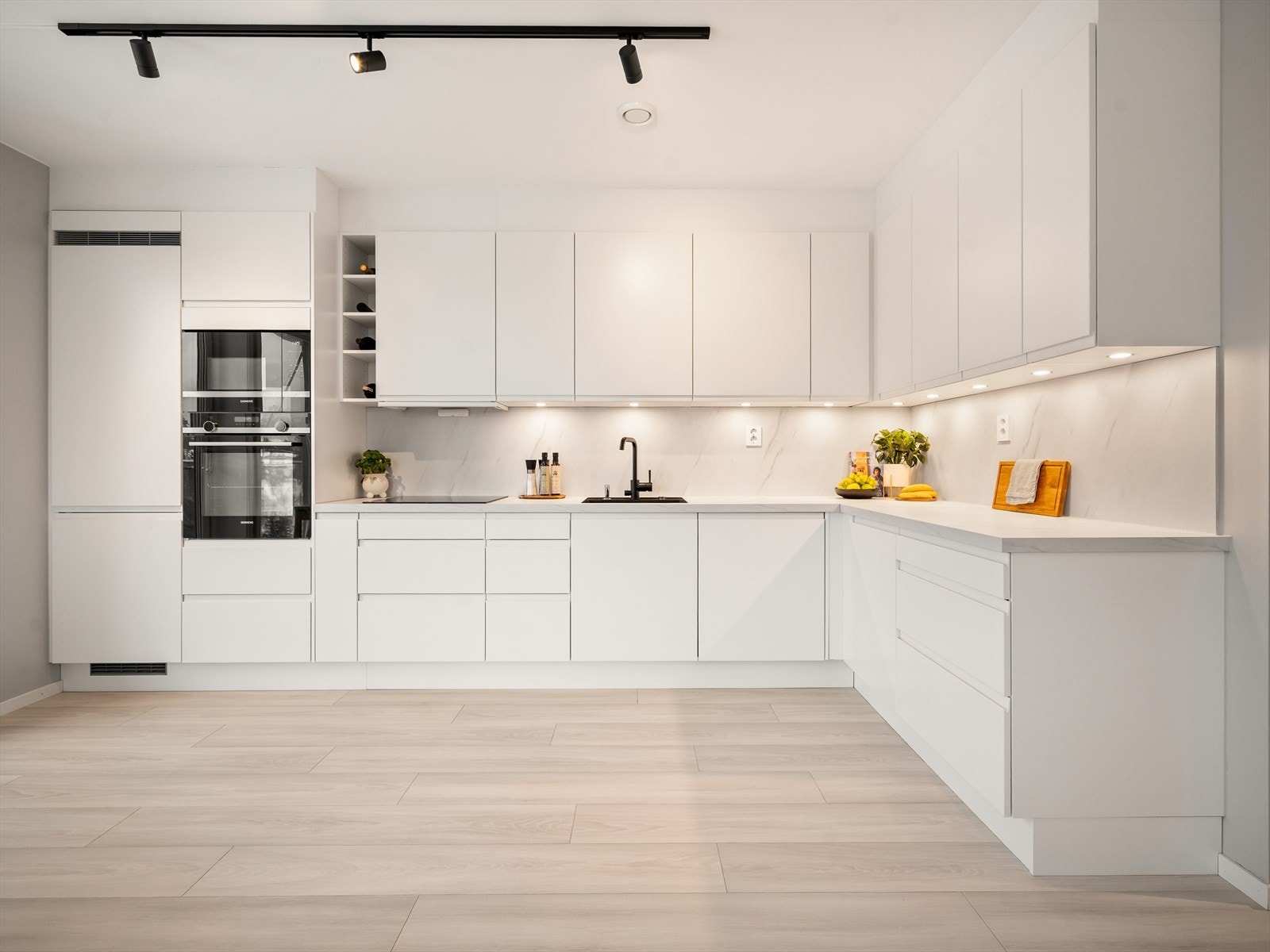 Leiligheten har en åpen stue- og kjøkkenløsning, med et stilrent kjøkken. Galleribilde