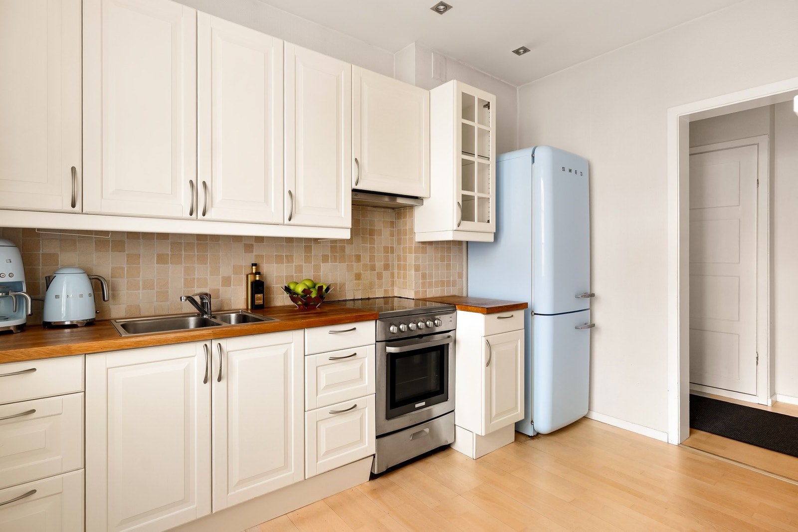 Kjøkkeninnredning med profilerte fronter og heltre benkeplate med nedfelt oppvaskkum. Galleribilde