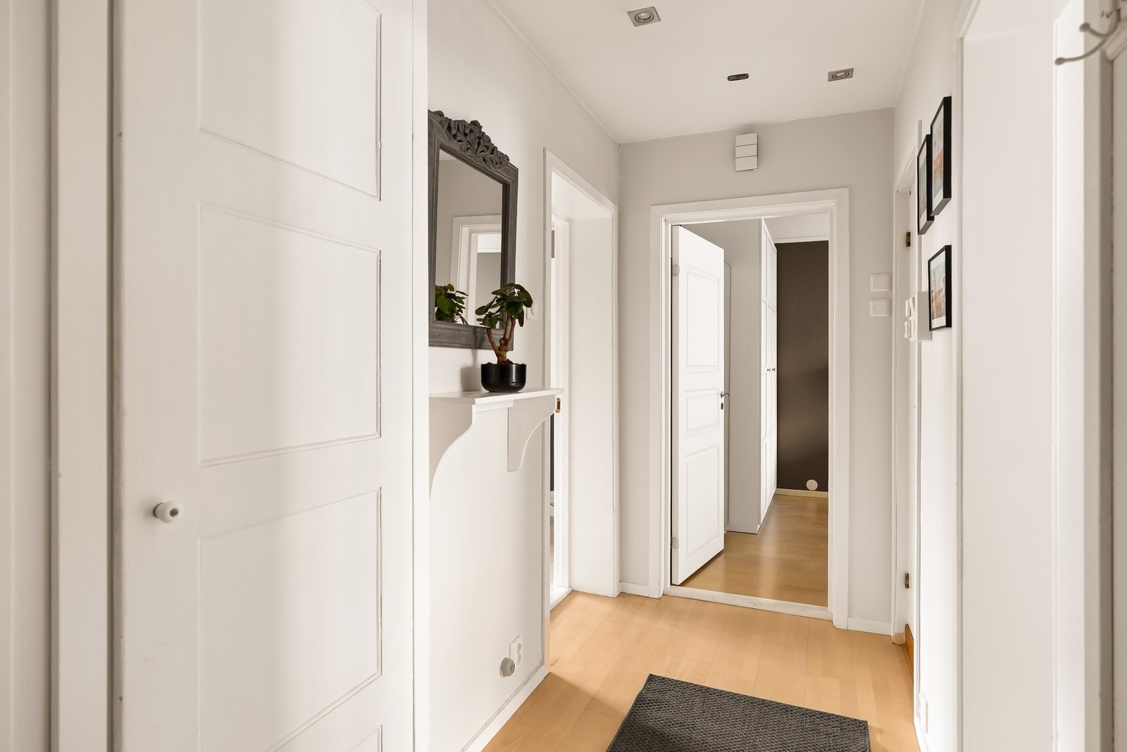 En praktisk entré med plass til oppheng av yttertøy og sko i innebygd garderobeskap eller på knaggrekke. Galleribilde