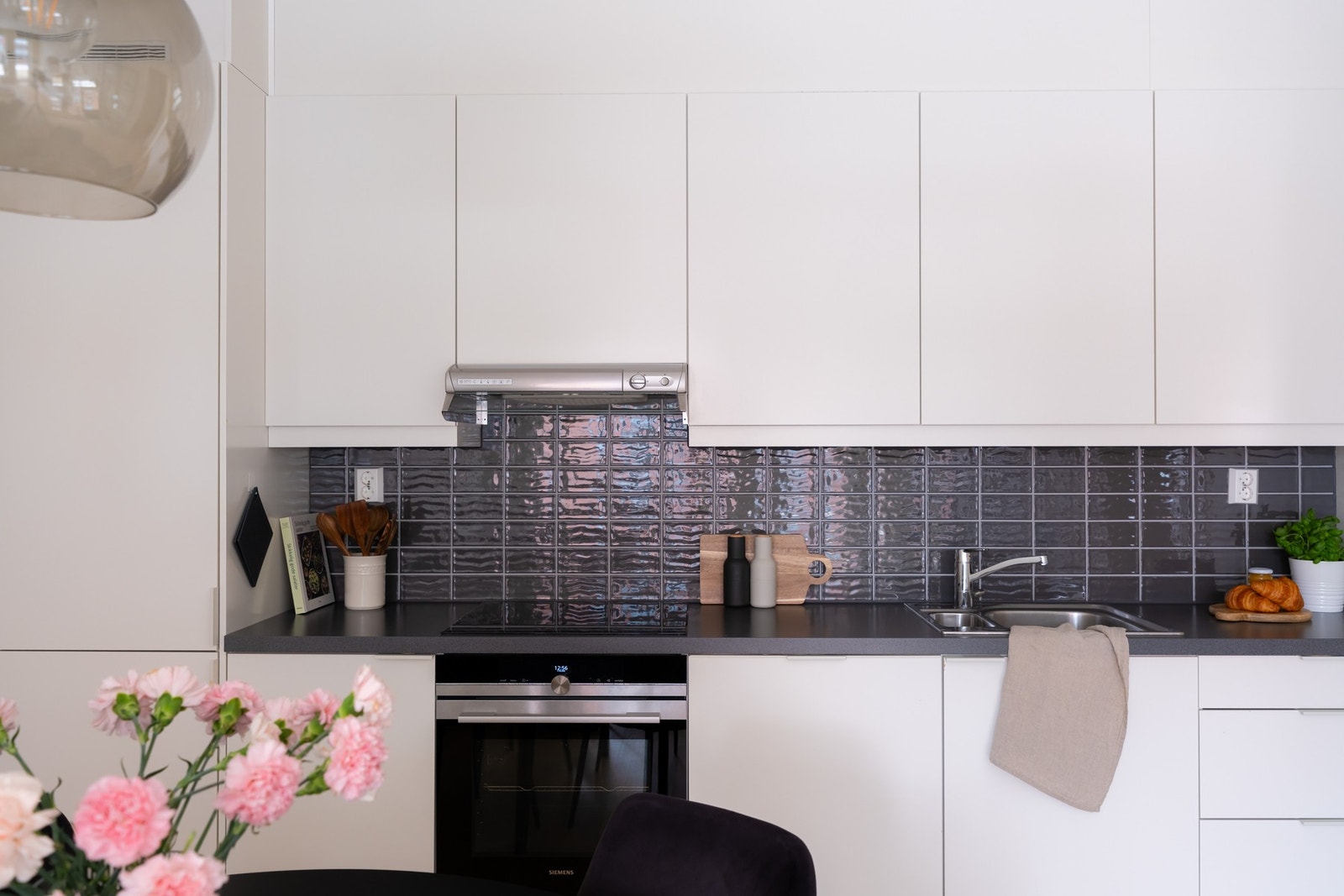 Lys innredning fra Sigdal som har glatte fronter og laminat benkeplate med nedfelt oppvaskkum og nedfelt induksjon koketopp. Galleribilde