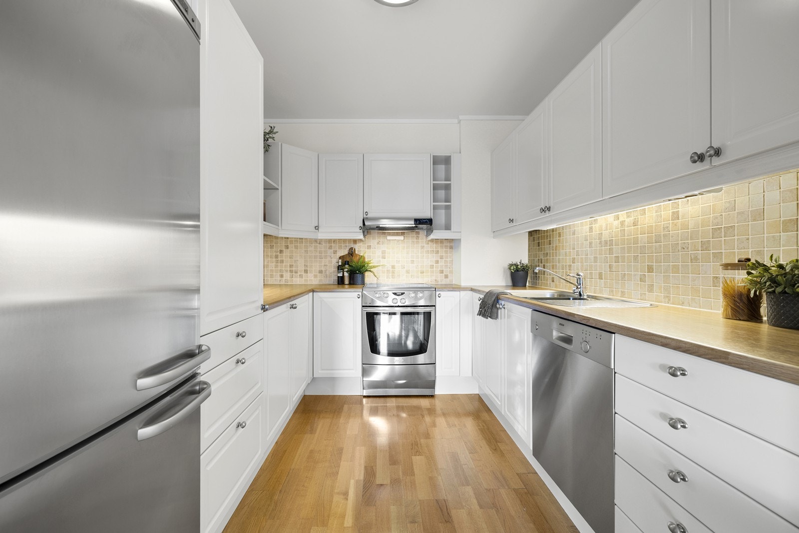 Innredningen er klassisk med hvite, profilerte fronter, laminat benkeplate og flislagt sprutsone. Galleribilde