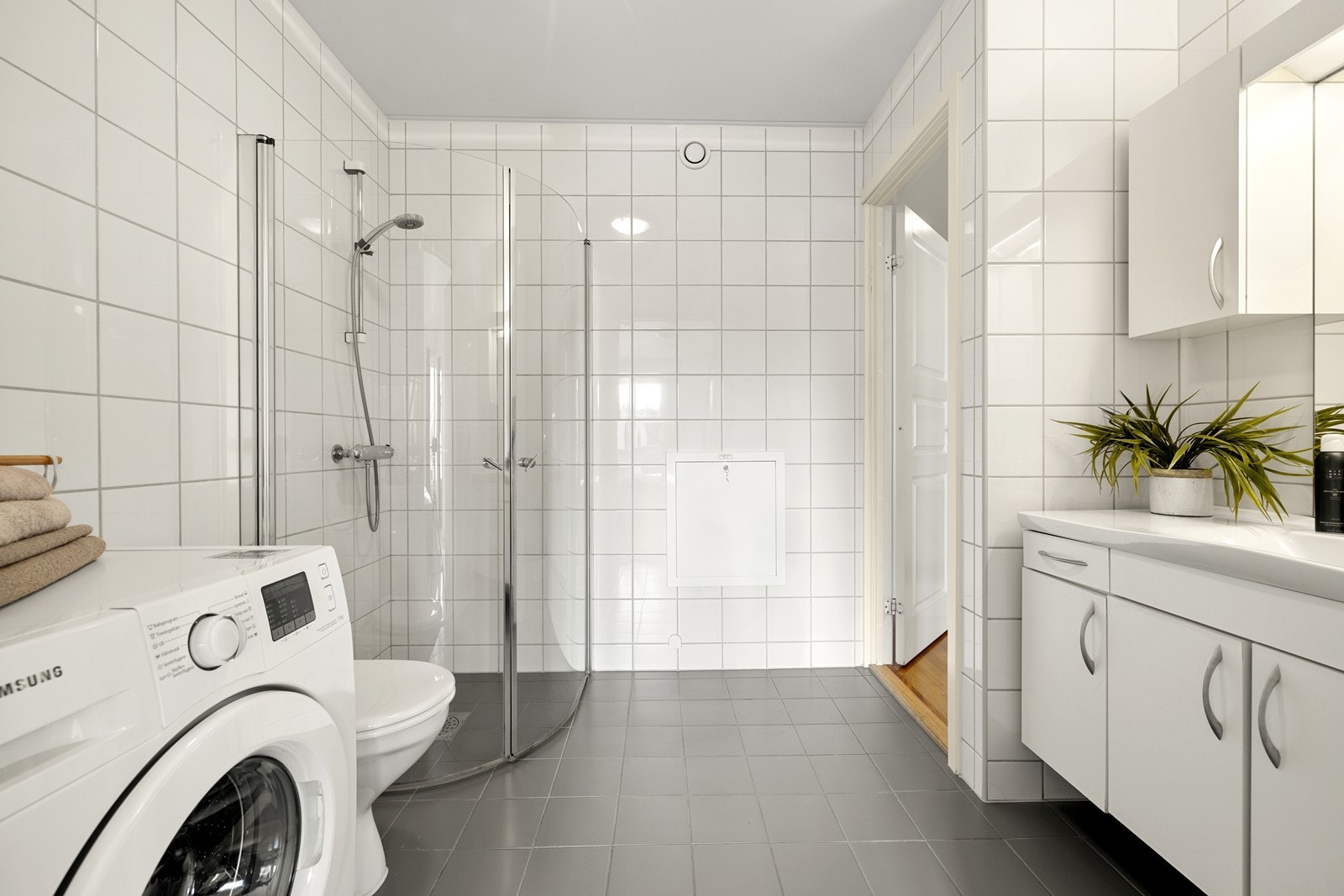 Badet er utstyrt med toalett, servant med skap og dusjnisje med innfellbare glassdører. Galleribilde