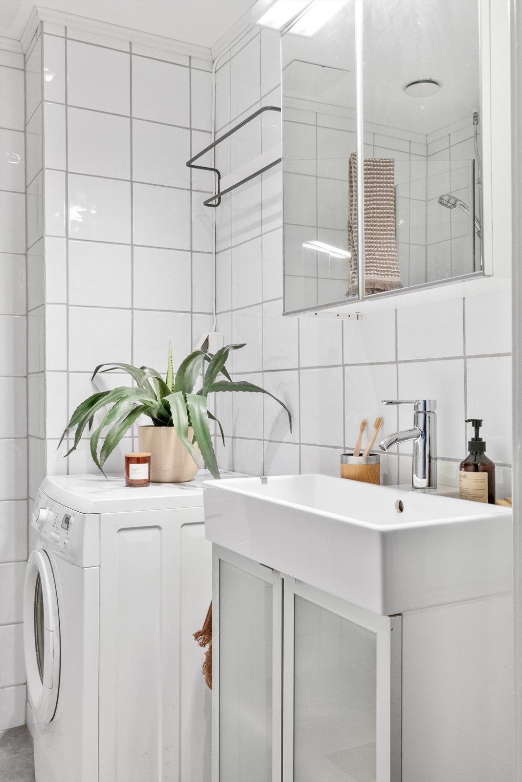 Badet er innredet med klosett, servant nedfelt i innredning, speilskap m/lys og dusjhjørne med svingbare glassdører. Galleribilde