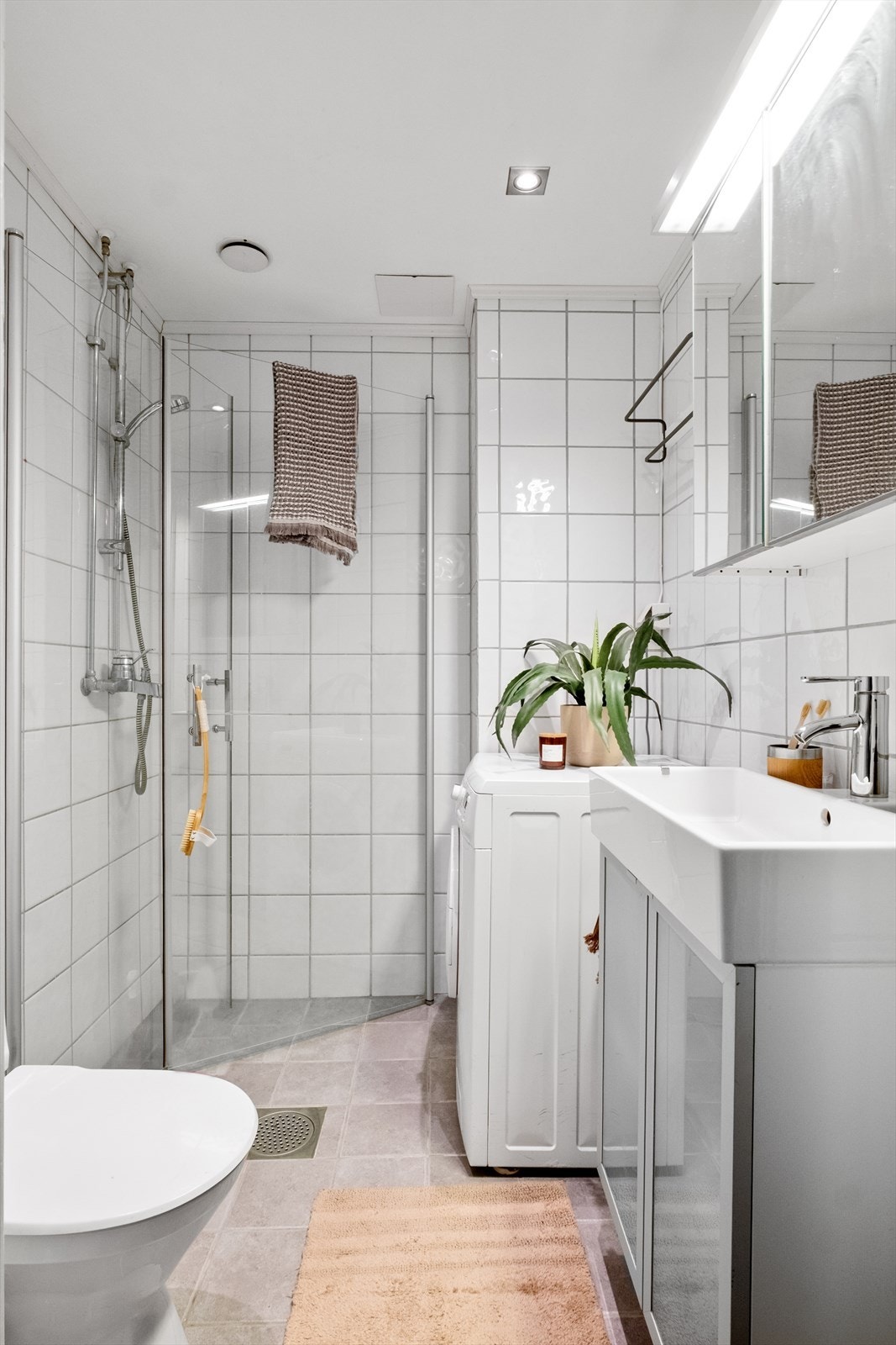 Tidløst, flislagt baderom med gulvvarme og opplegg for vaskemaskin. Galleribilde