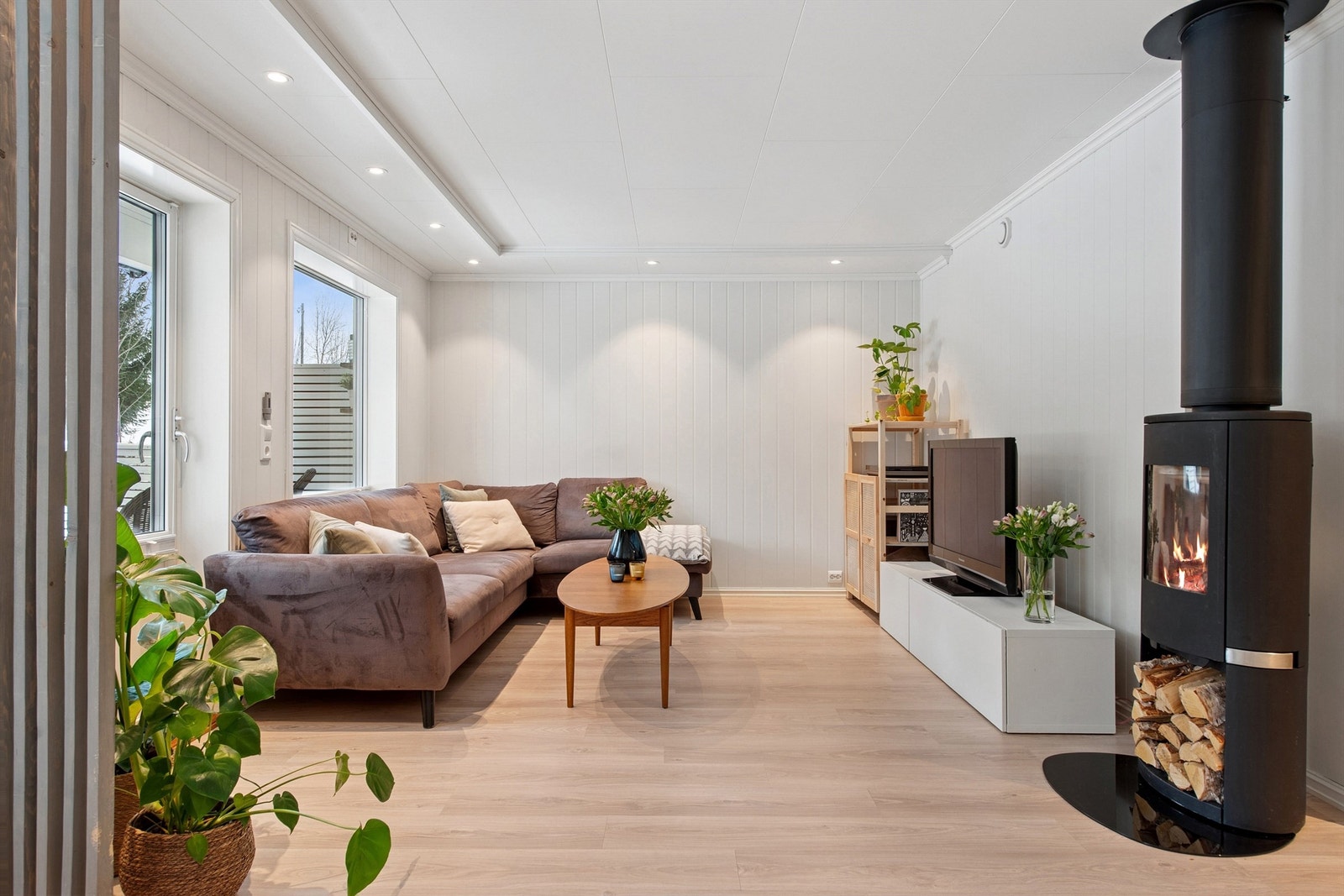 Lys og delikat stue med downlights og store vindusflater Galleribilde