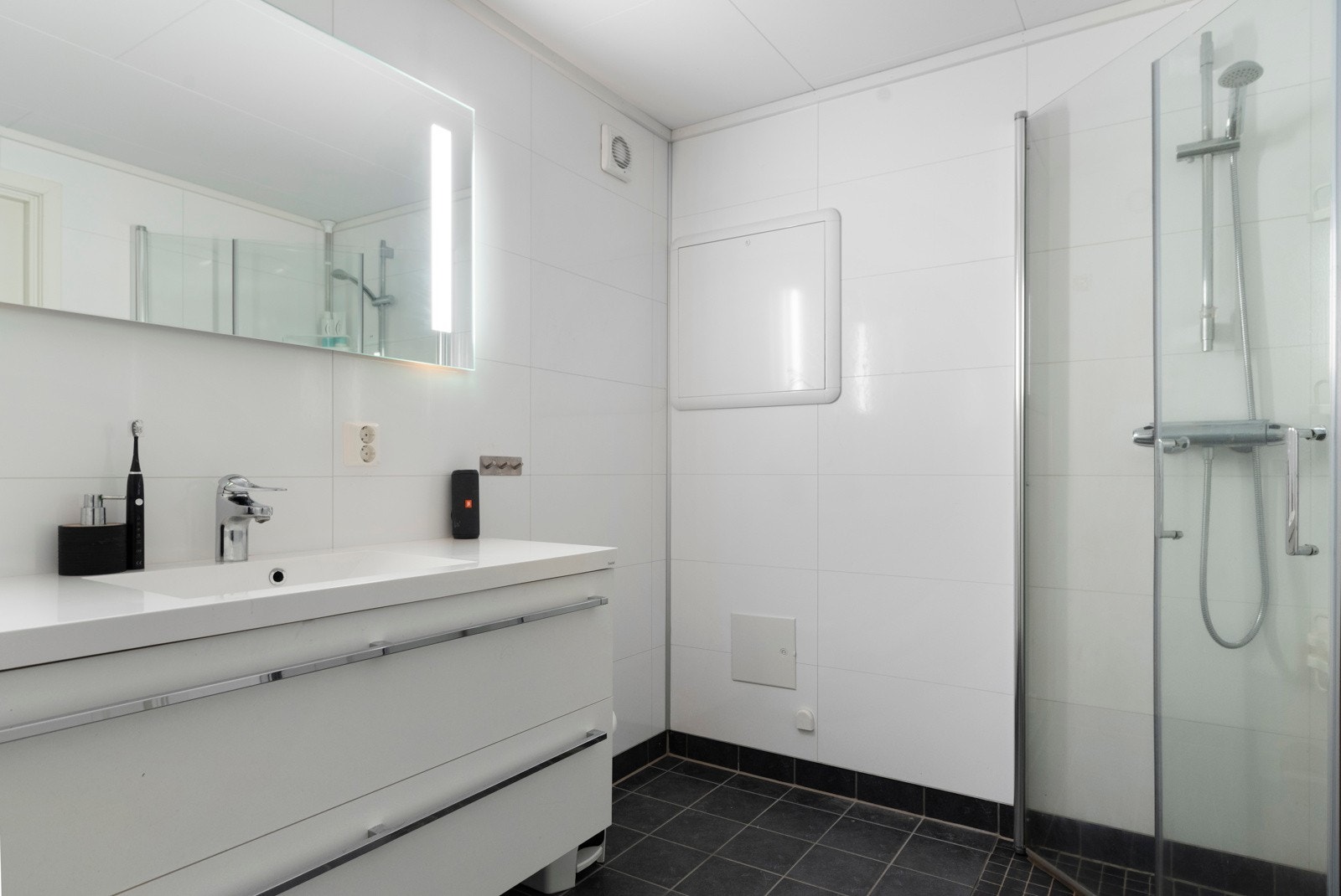 Flott bad med dusjhjørne og servant med skuffer. Galleribilde