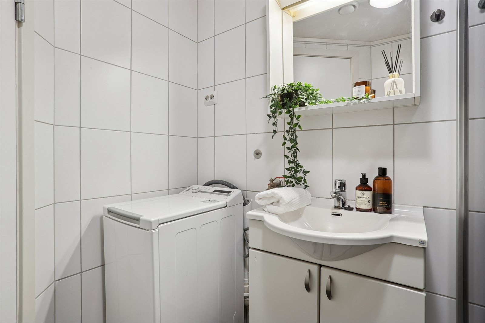 Lyst og funksjonelt bad med integrert plass for vaskemaskin. Galleribilde