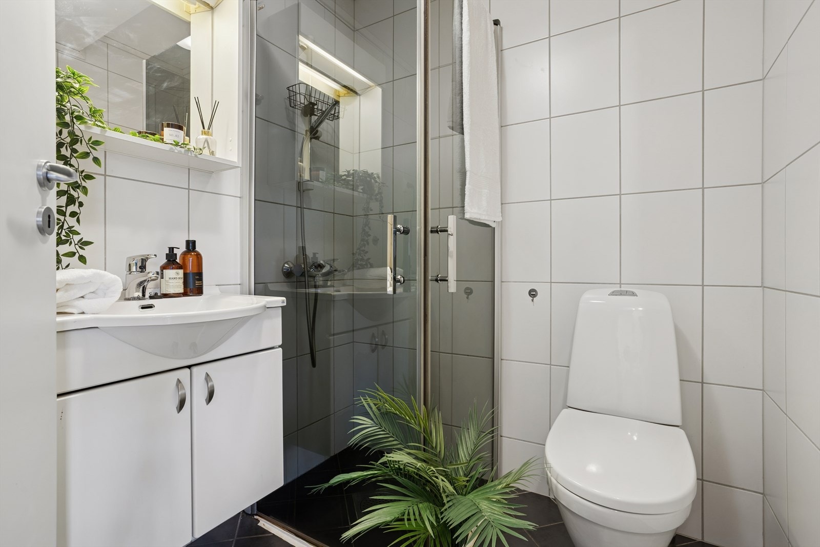 Flislagt bad med dusjhjørne, oppbevaring og praktisk innredning. Galleribilde