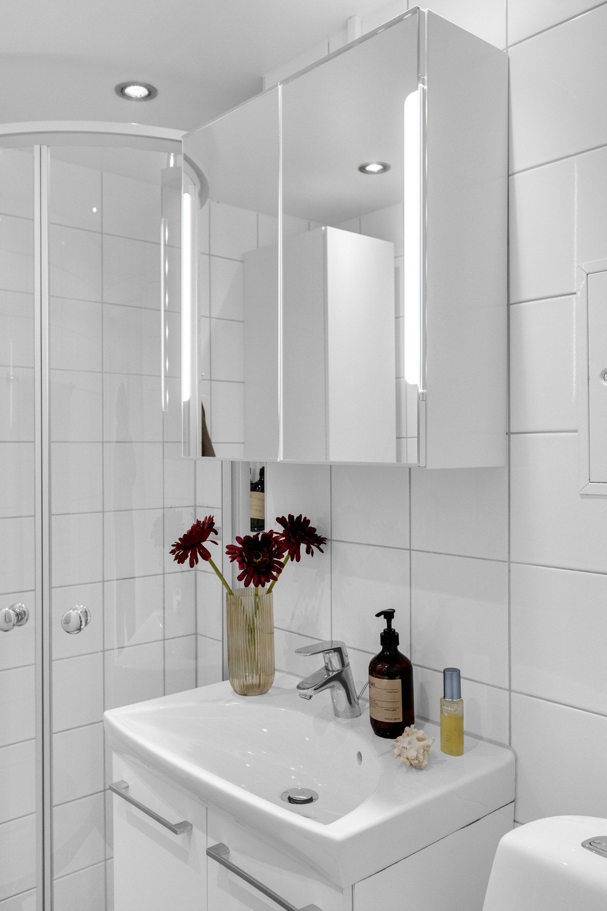 Badet er innredning med nedfelt servant, toalett og speilskap med belysning Galleribilde