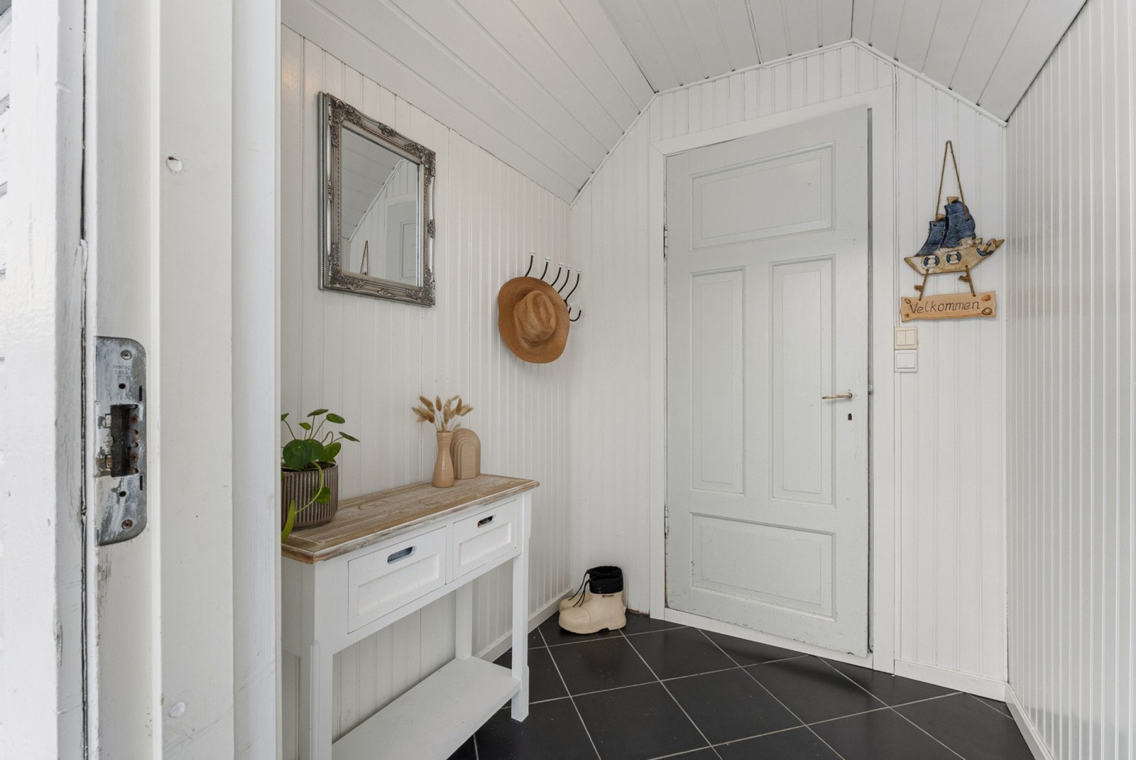 Inngangspartiet ønsker deg velkommen inn i en praktisk entré som fungerer som et naturlig knutepunkt i boligens første etasje. Galleribilde