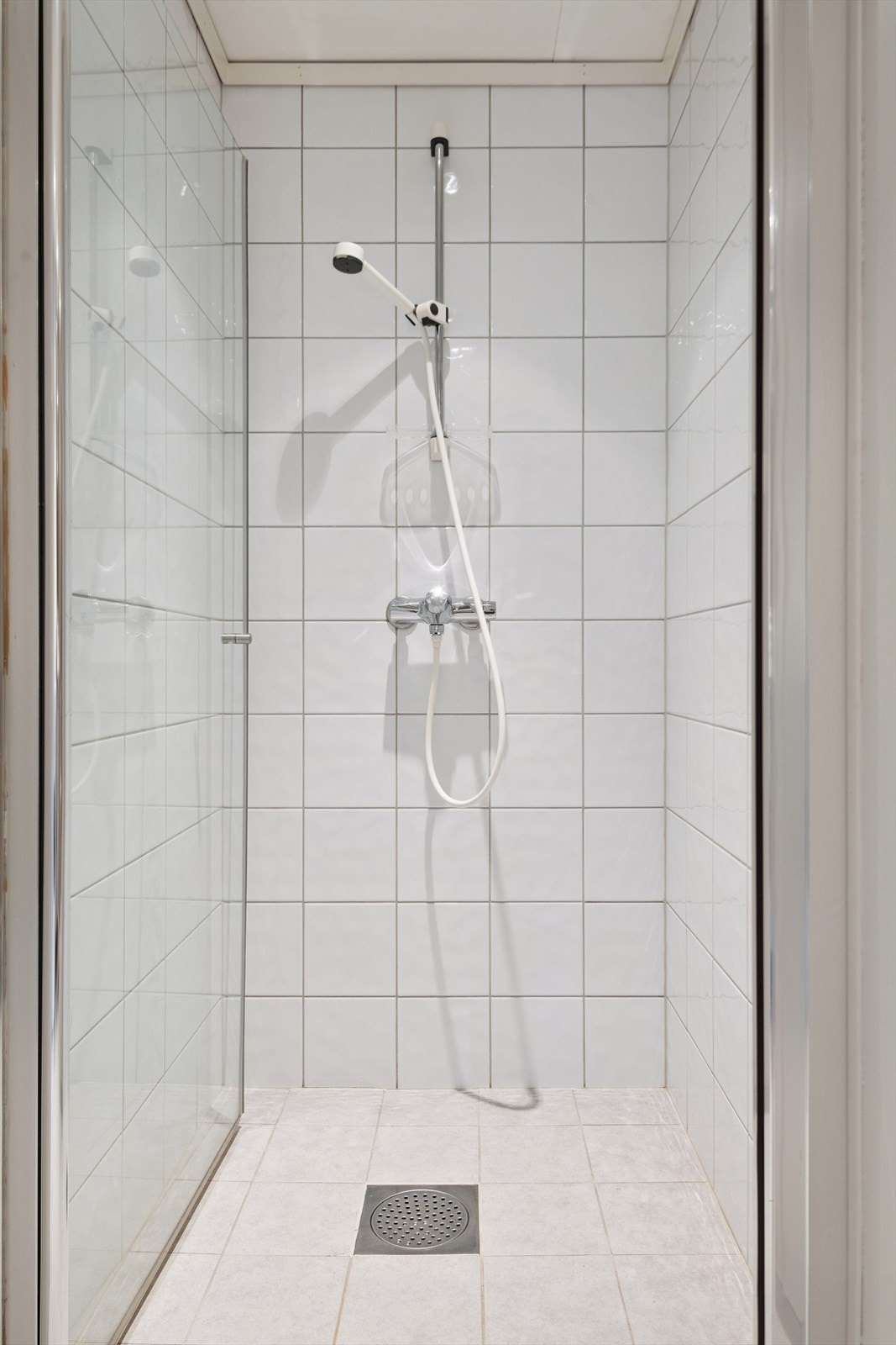 Dusjsonen har flislagte vegger og praktiske dusjdører i glass. Galleribilde