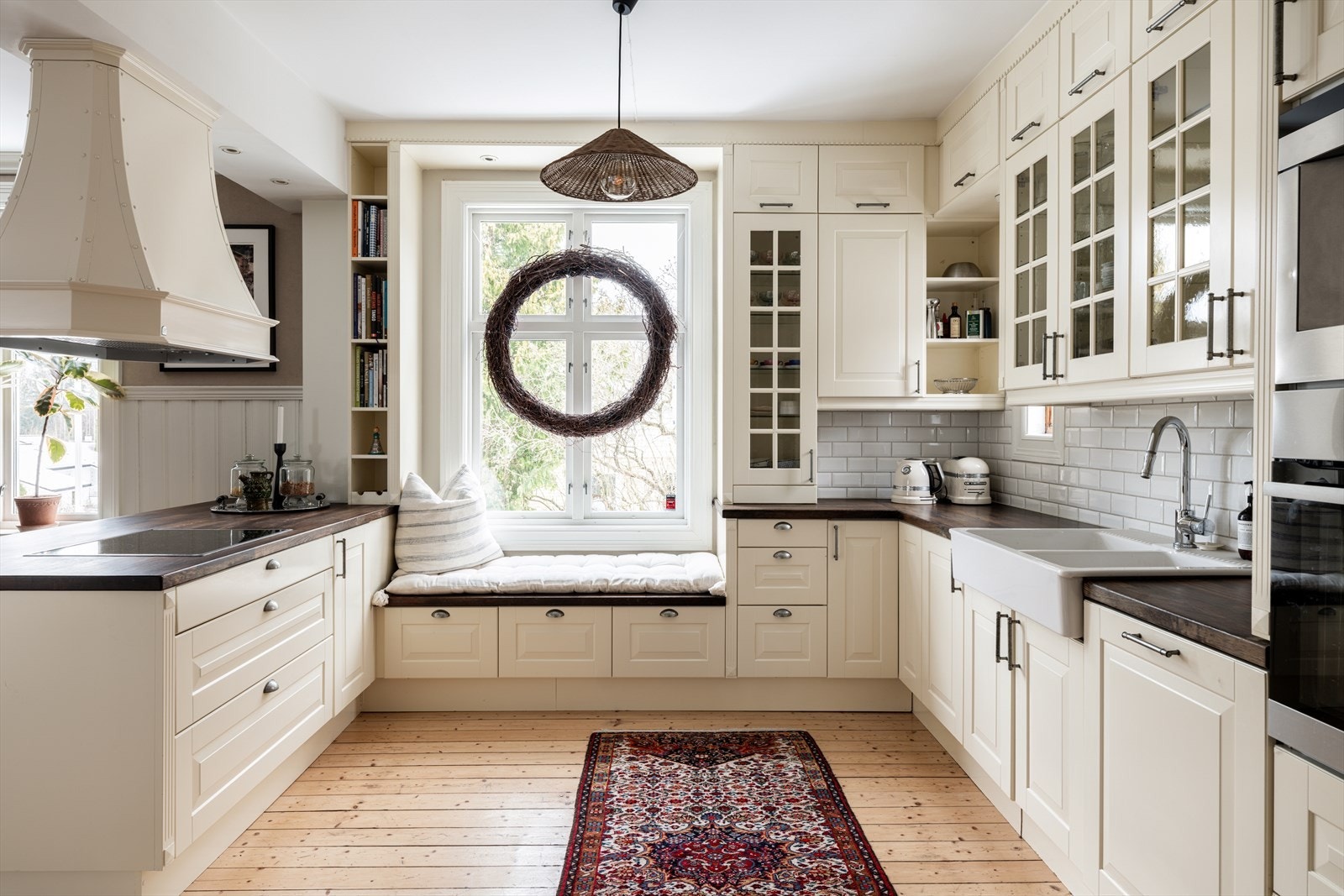 Kjøkkenet har heltre benkeplater med fliser over arbeidsbenk, dobbel porselensvask med ettgreps kjøkkenkran med uttrekkbar hånddusj, nedfelt induksjonstopp samt kjøkkenvifte med avtrekk til kanal Galleribilde