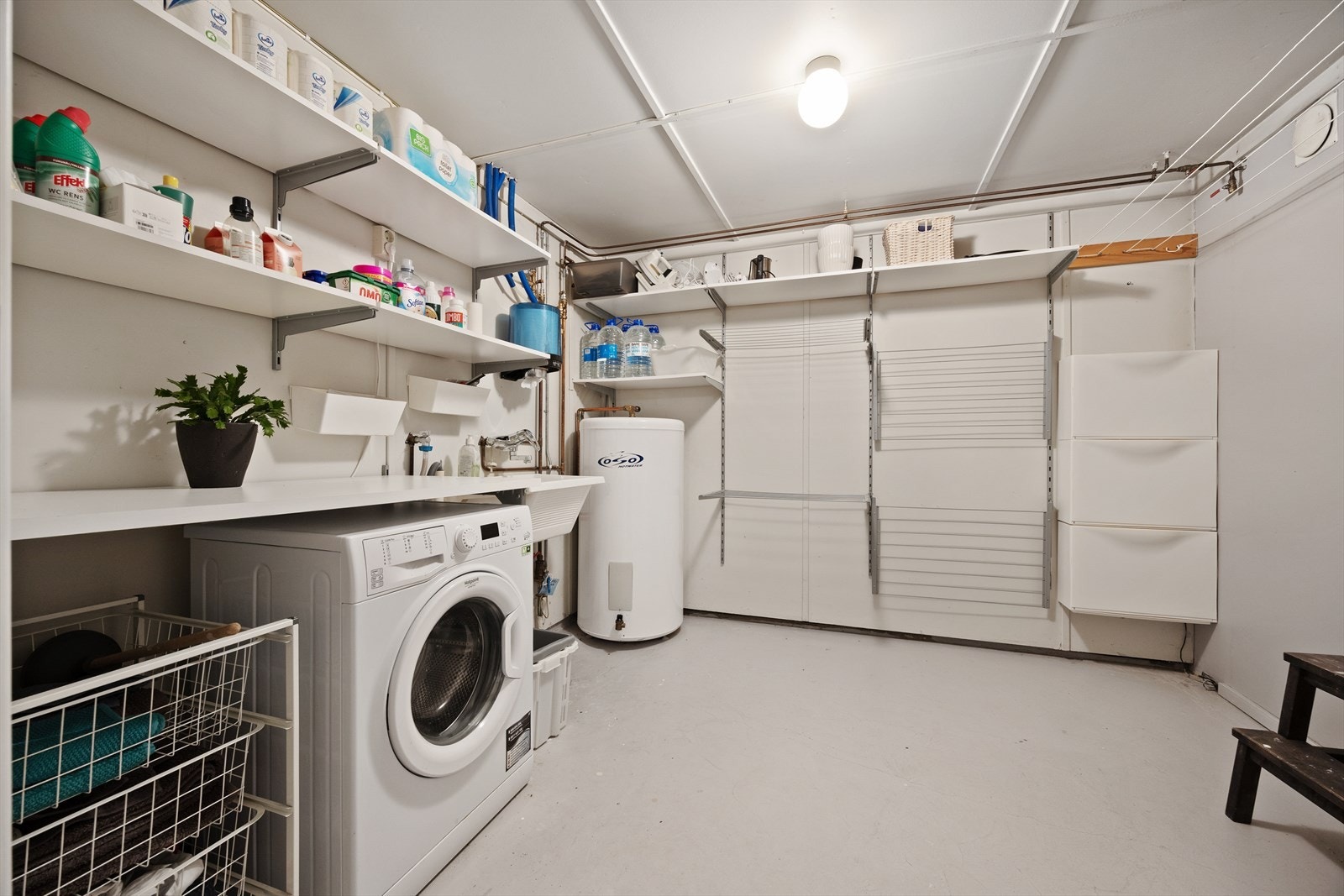 Et stort og funksjonelt vaskerom med opplegg for vaskemaskin og god lagringsplass Galleribilde