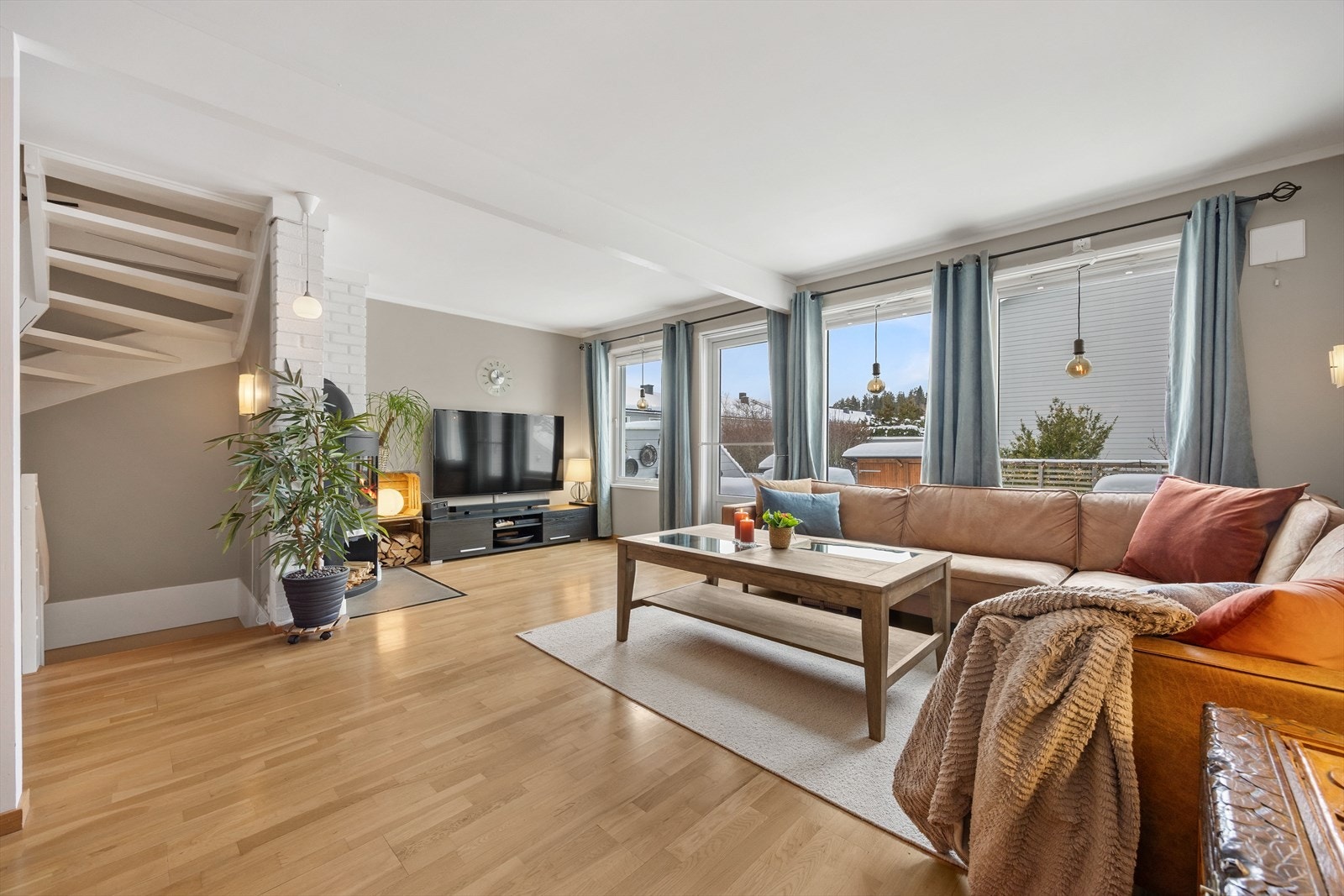 De store vindusflatene gir rikelig med naturlig lys inn i stuen Galleribilde