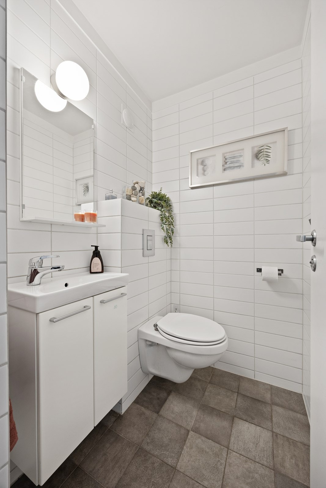 Praktisk toalettrom i første etasje med flislagt gulv, varmekabler og vegghengt toalett Galleribilde