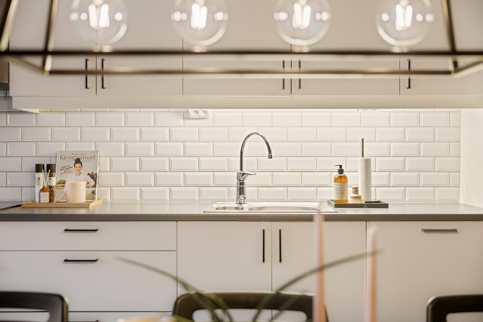 Kjøkkenet har innredning med glatte fronter og det er lagt fliser på vegg over benkeplate. Galleribilde