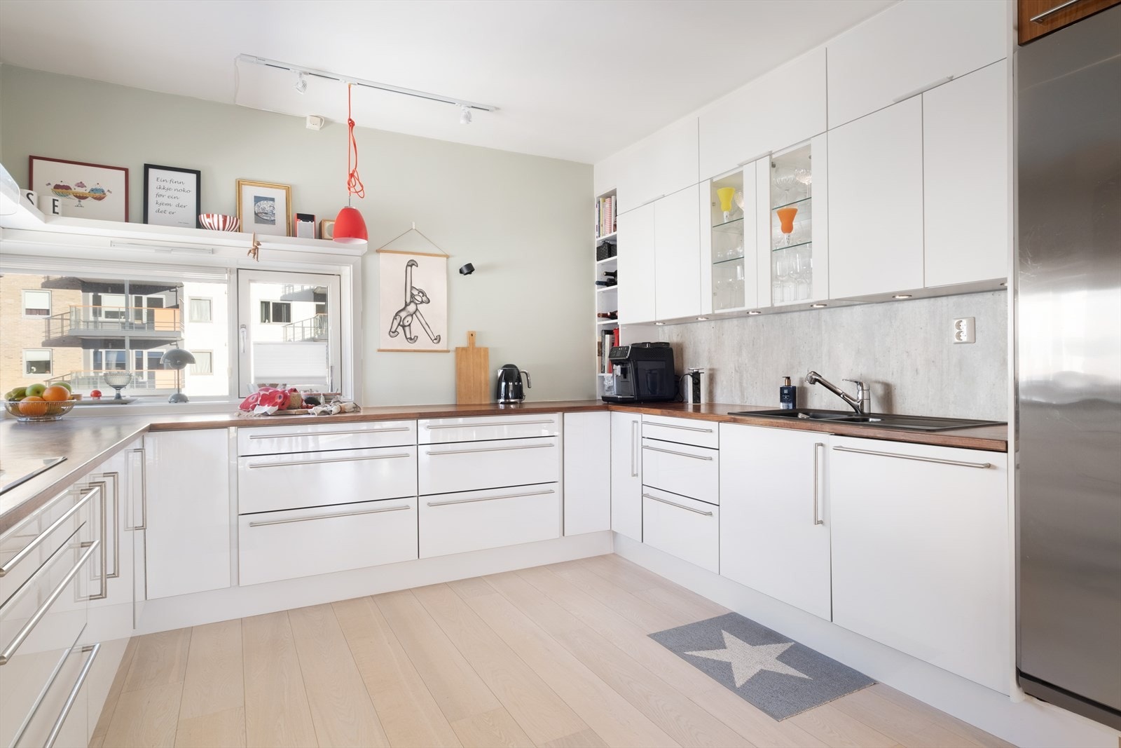 Skreddarsydd kjøken frå Sognatre. Kjøkenet er romsleg og velutstyrt, med rikeleg benkeplass og gode arbeidsflater - utforma i eit tidlaust og stilreint uttrykk. Nye overskåp over vask er skifta ut i 2021, og er av type AUBO. Galleribilde