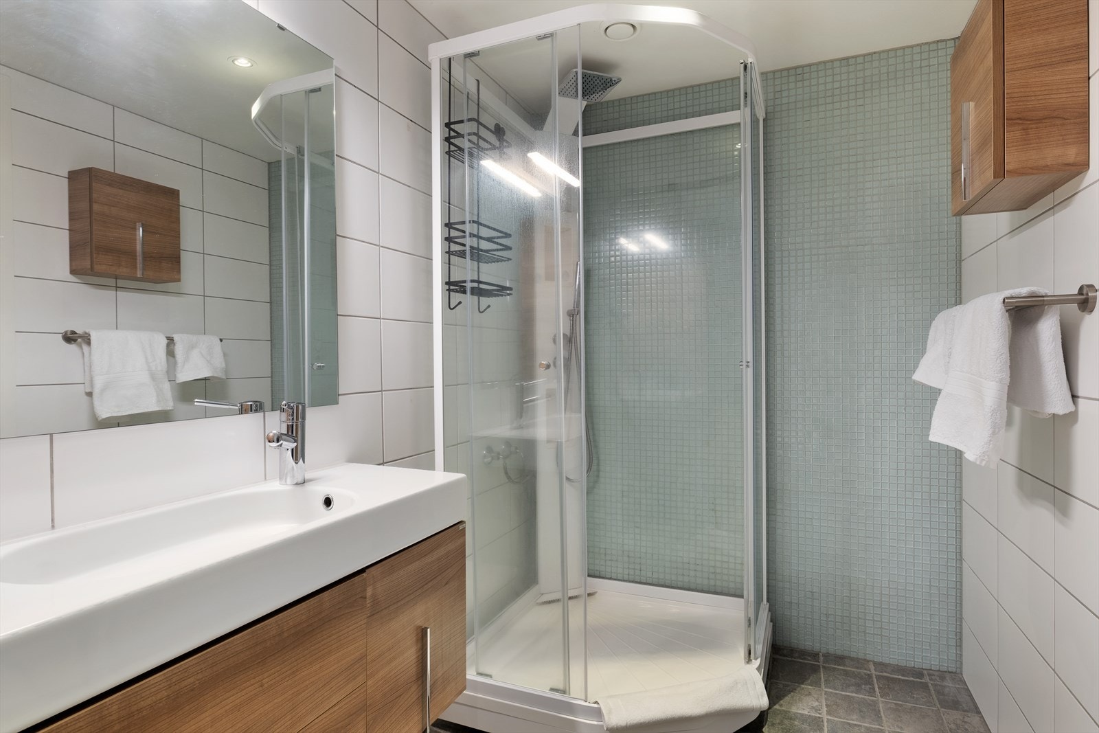 Baderom nr 2 inneheld dusjkabinett, servant i innredning, sideskåp og veggmontert klosett. Galleribilde