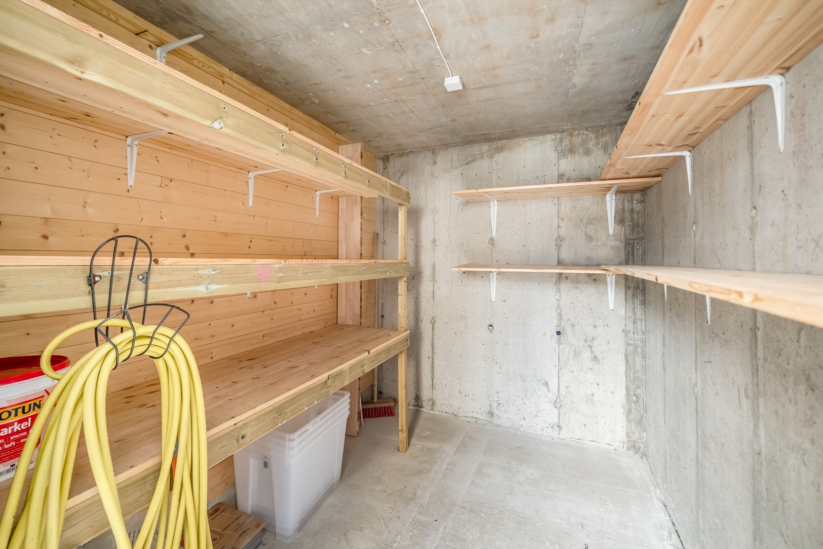 Romslig bod like ved inngangspartiet med faste hyller og gode lagringsmuligheter. Galleribilde