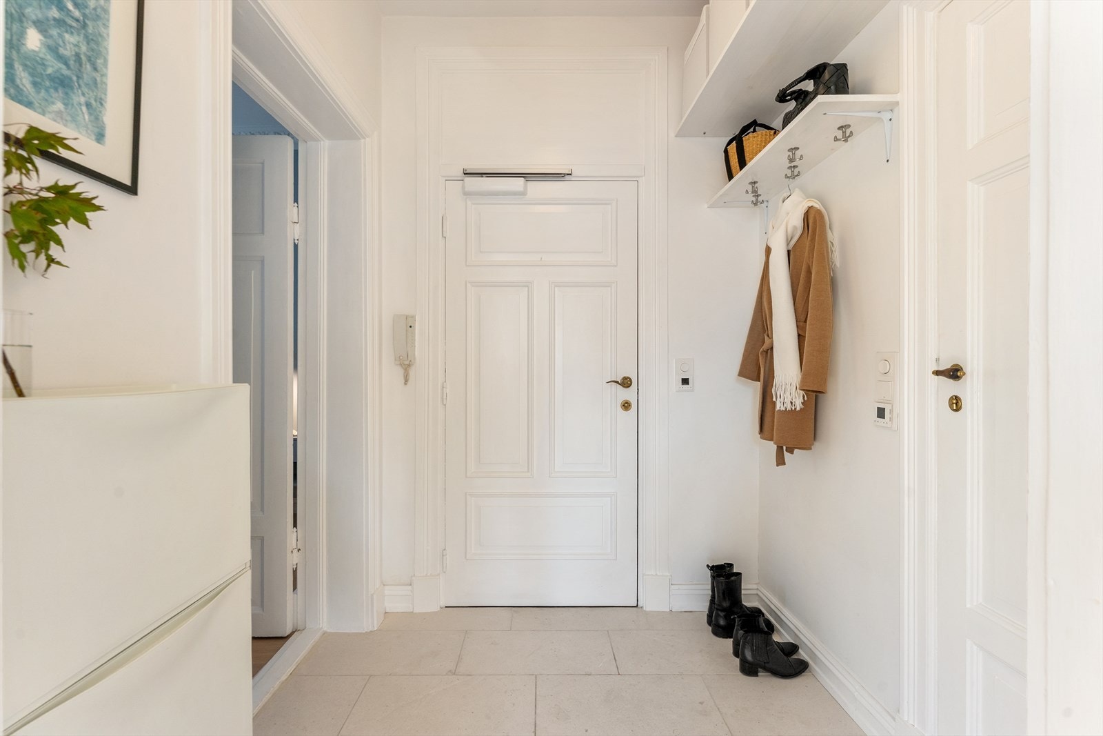 Lys og innbydende entré med flislagt gulv og elektrisk gulvvarme. Galleribilde