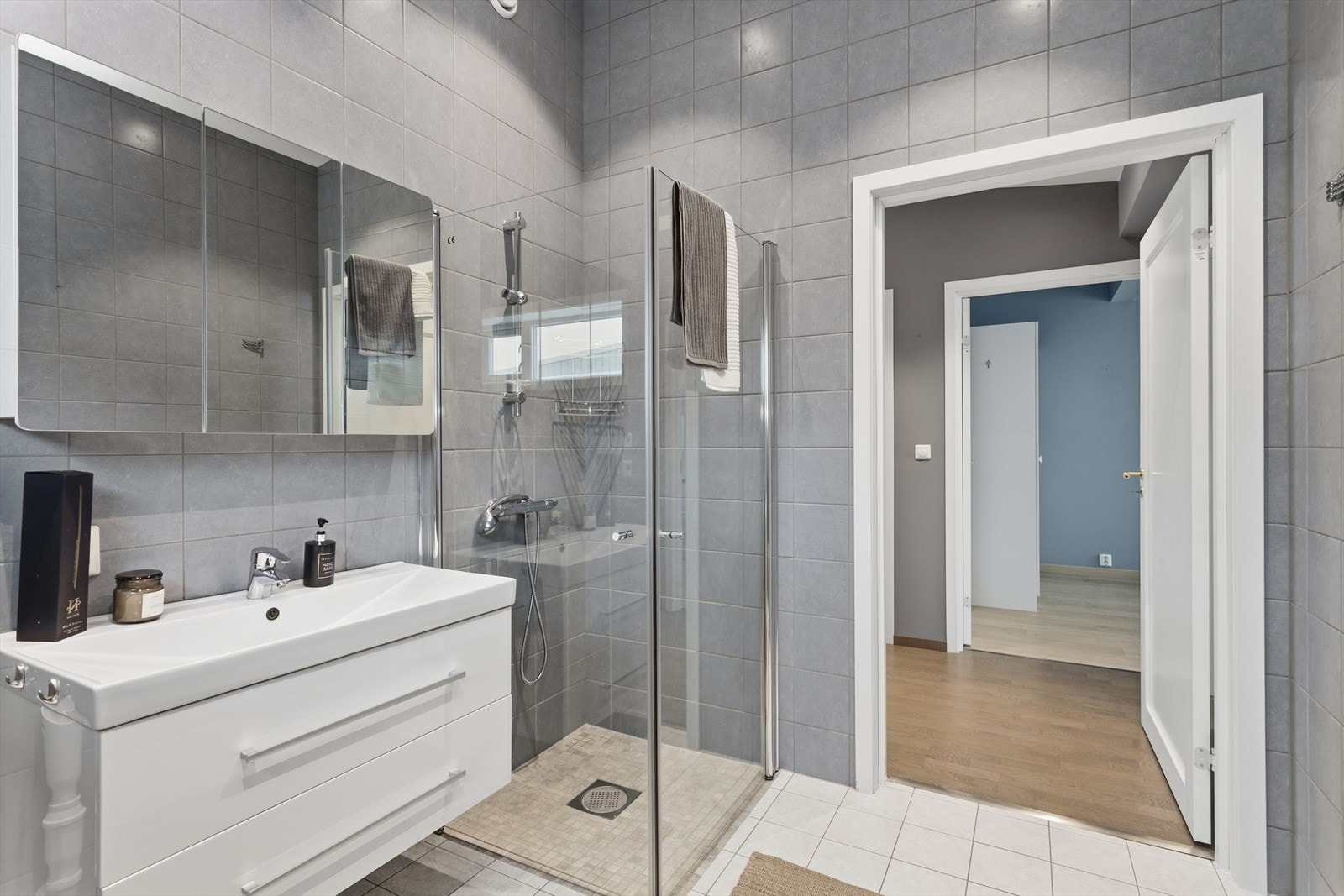 Leiligheten har et romslig bad med delikate fliser på gulv og vegger. Også her preges rommet og romfølelsen av det høye taket. Flisvalget på gulv og vegger gir en fin helhetsfølelse - det er elektriske varmekabler! Galleribilde