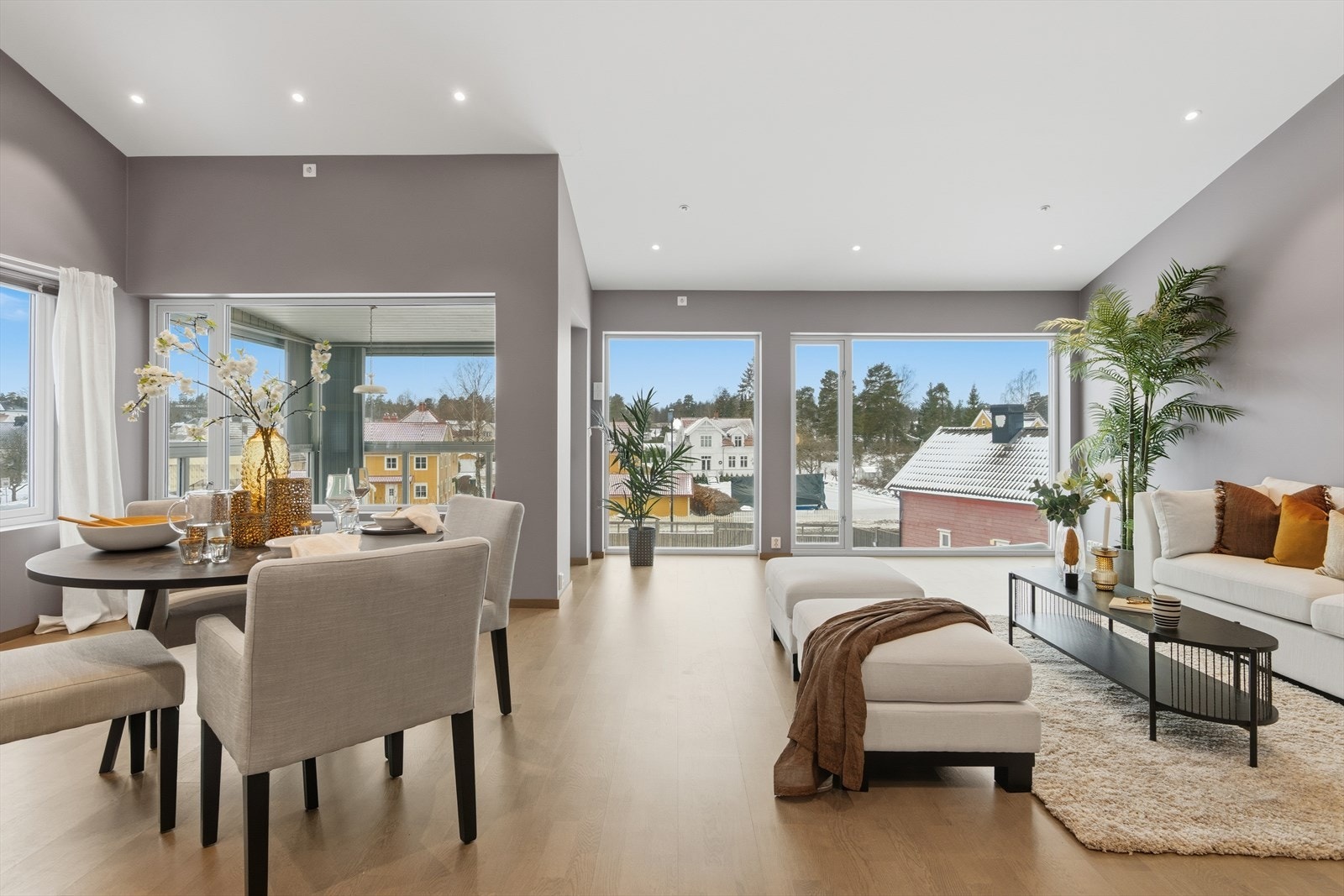 Stuen ligger i åpen løsning mot spisestuen. Sammen danner disse rommene en herlig romfølelse takket være den gjennomlyste løsningen med store vindusflater og ikke minst den imponerende høye mønehimlingen. Galleribilde