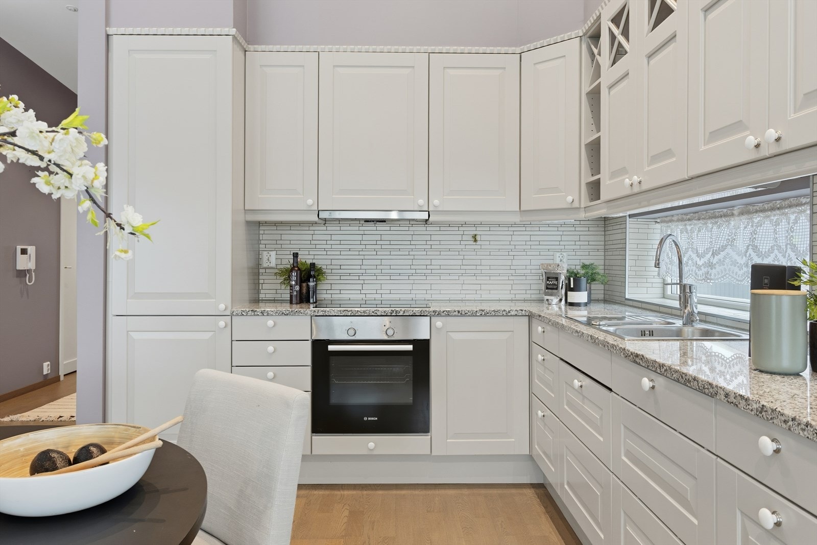 Her finer man blant annet ekstra høye overskap, god belysning til benkeplatene plassert under overskap og benkeplate i stein som matcher i kontrast øvrige interiørfarger. Galleribilde