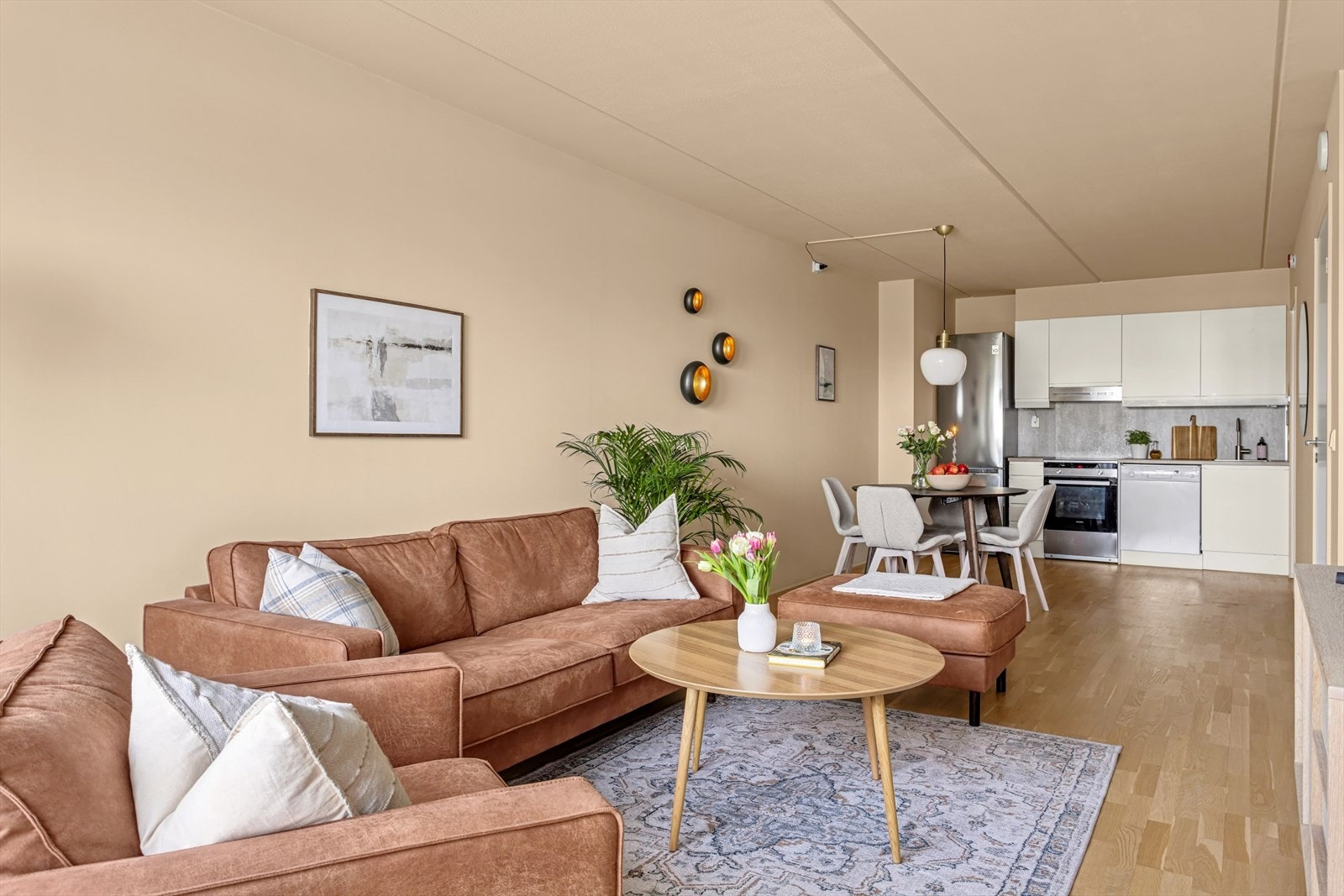 Leiligheten har en åpen stue- og kjøkkenløsning som gir en luftig romfølelse, med god plass til både spisebord og sofagruppe. Galleribilde