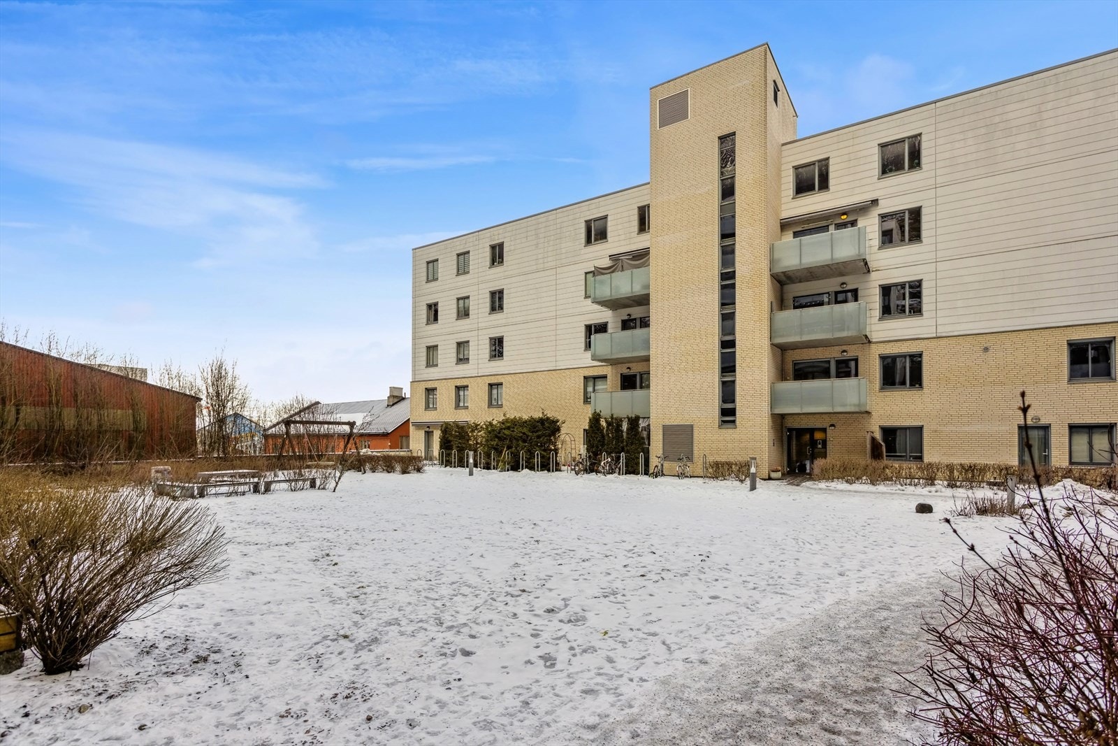 Romslig gårdsrom med sittegrupper og sykkelparkering. Det er også felles innedørs sykkelparkering i borettslaget. Galleribilde