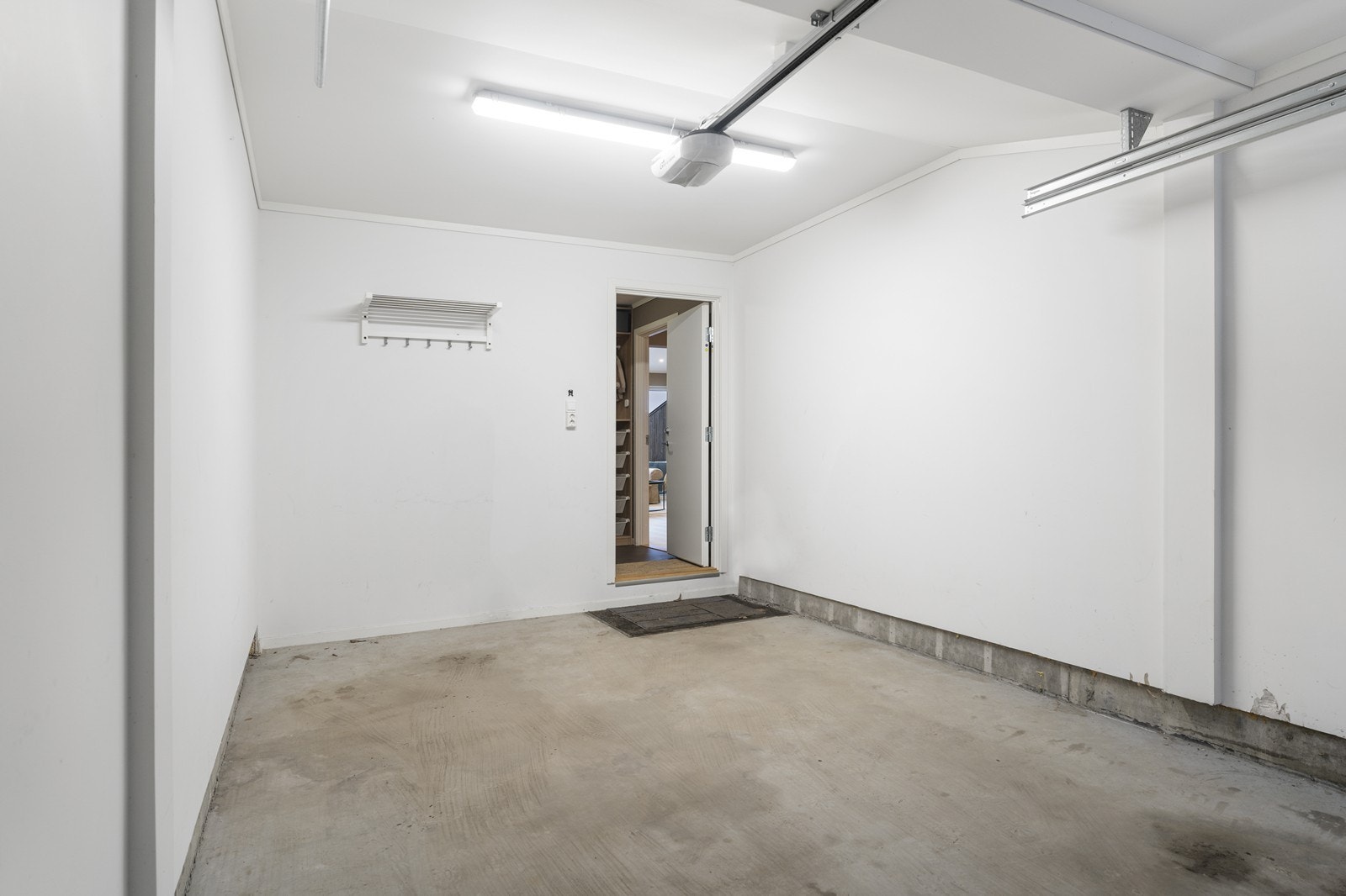Garasje med adkomst fra bakkeplan og direkte inngang til boligens hovedetasje. Galleribilde