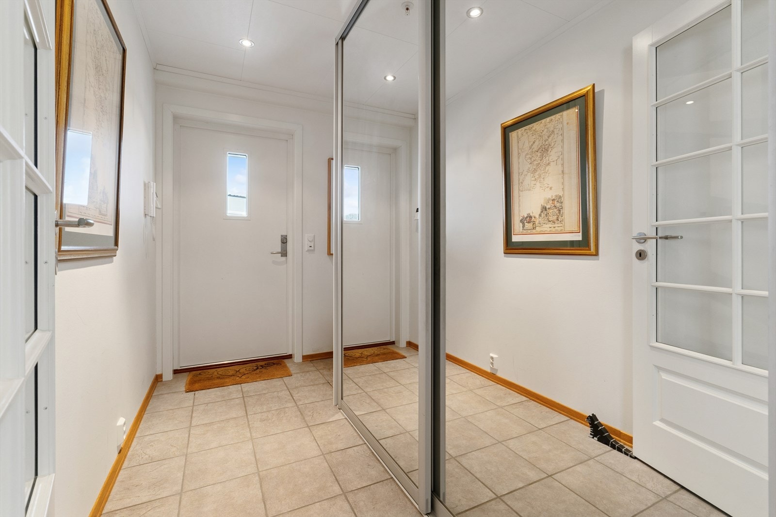 Innbydende entré med gulvvarme og en romslig skyvedørsgarderobe med speilfronter. Galleribilde