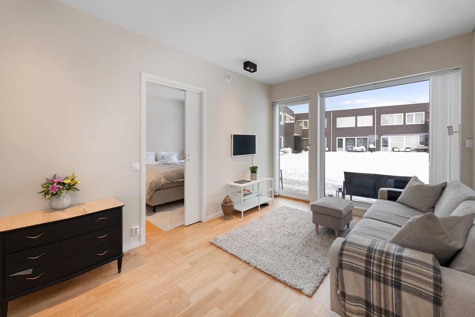 Stue med utgang til terrasse vendt mot hyggelig fellesområde Galleribilde