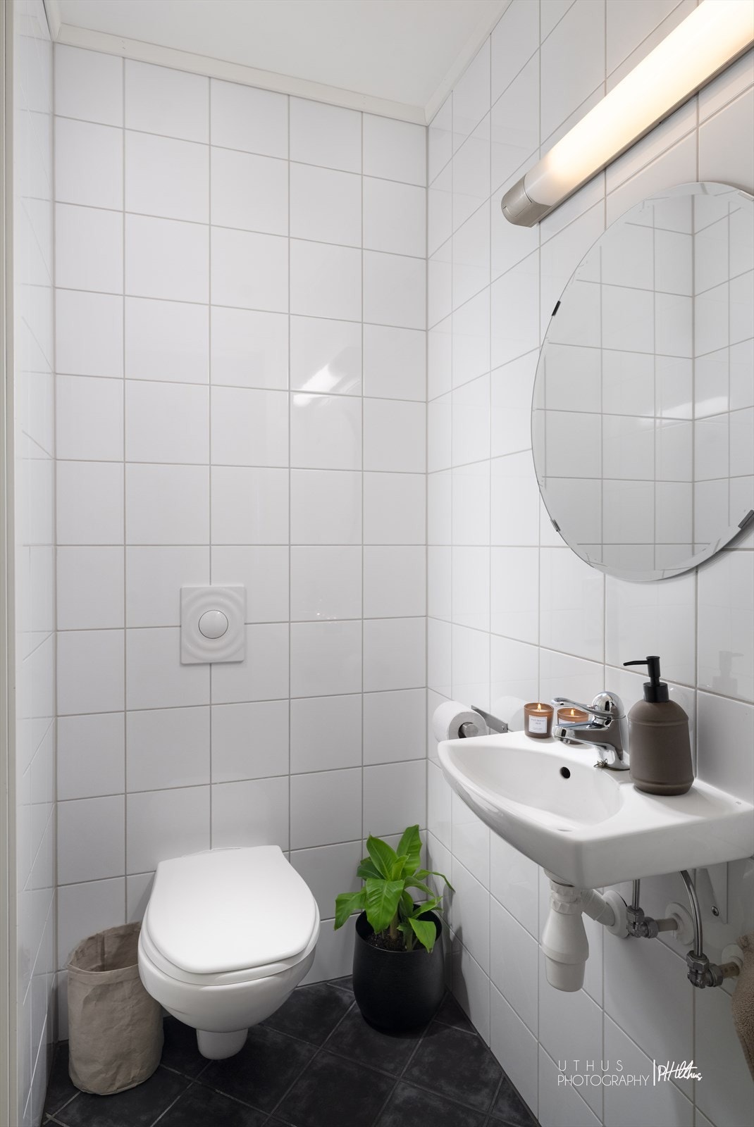 Toalettrommet har flislagte overflater på gulv og vegger og er innredet med toalett og servant. Galleribilde