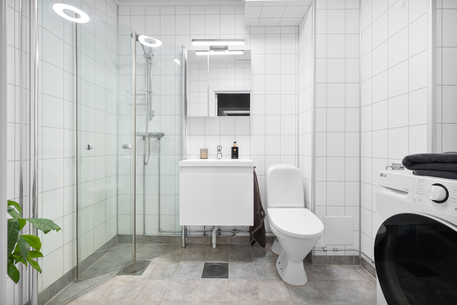 Baderom fra 2010 med flislagt gulv med varme og baderomsplater på veggene. Innredningen består av en servant nedfelt i underskap og et praktisk speilskap med belysning. Galleribilde