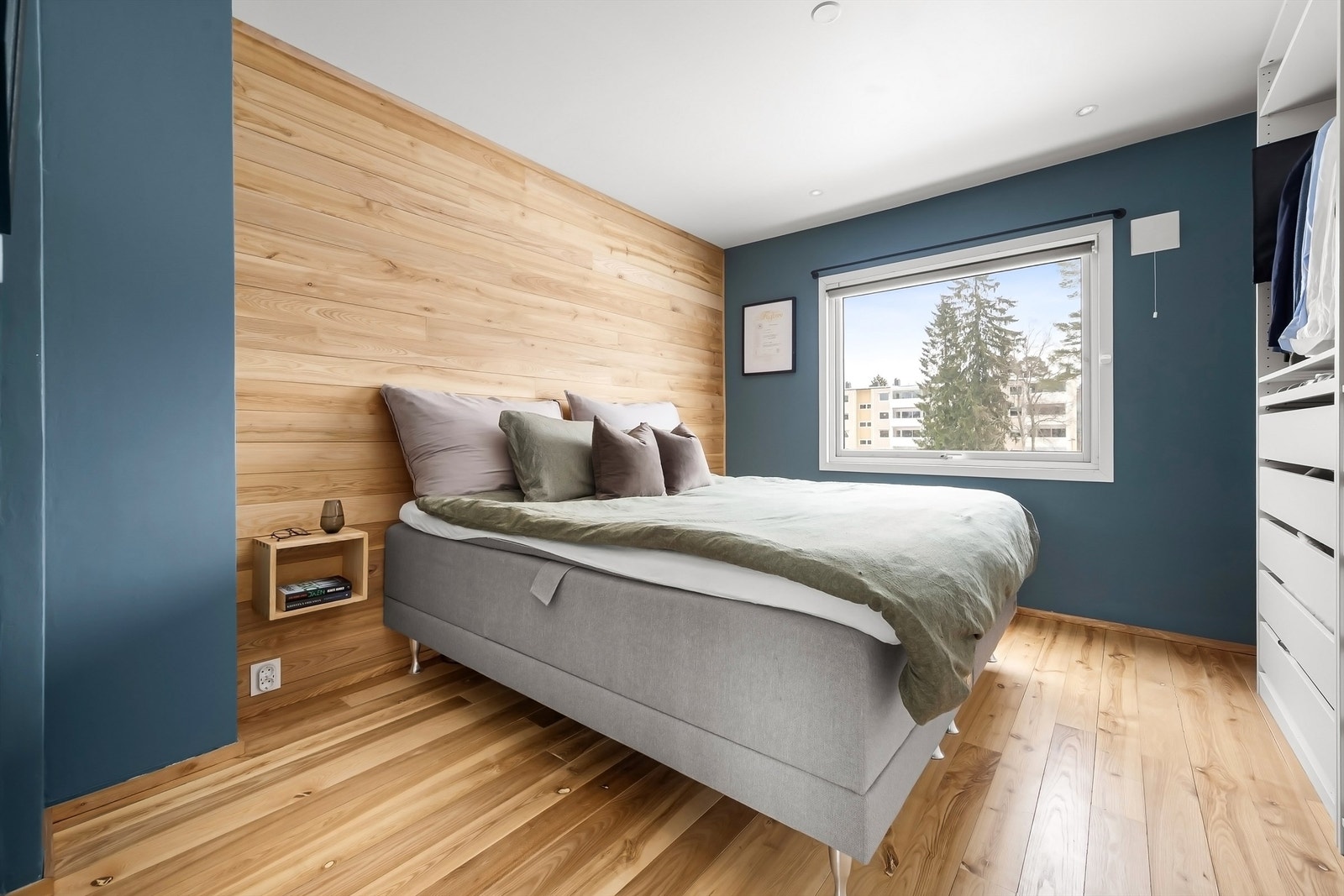 Hovedsoverommet har en lun atmosfære med panel på fondveggen. Galleribilde