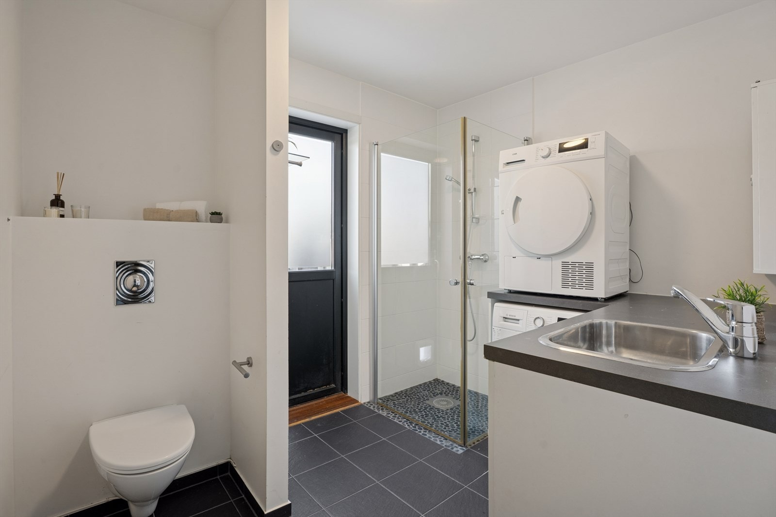 Pent bad/vaskerom som også har egen inngang. Det er satt inn en praktisk innredning med god oppbevaringsplass Galleribilde