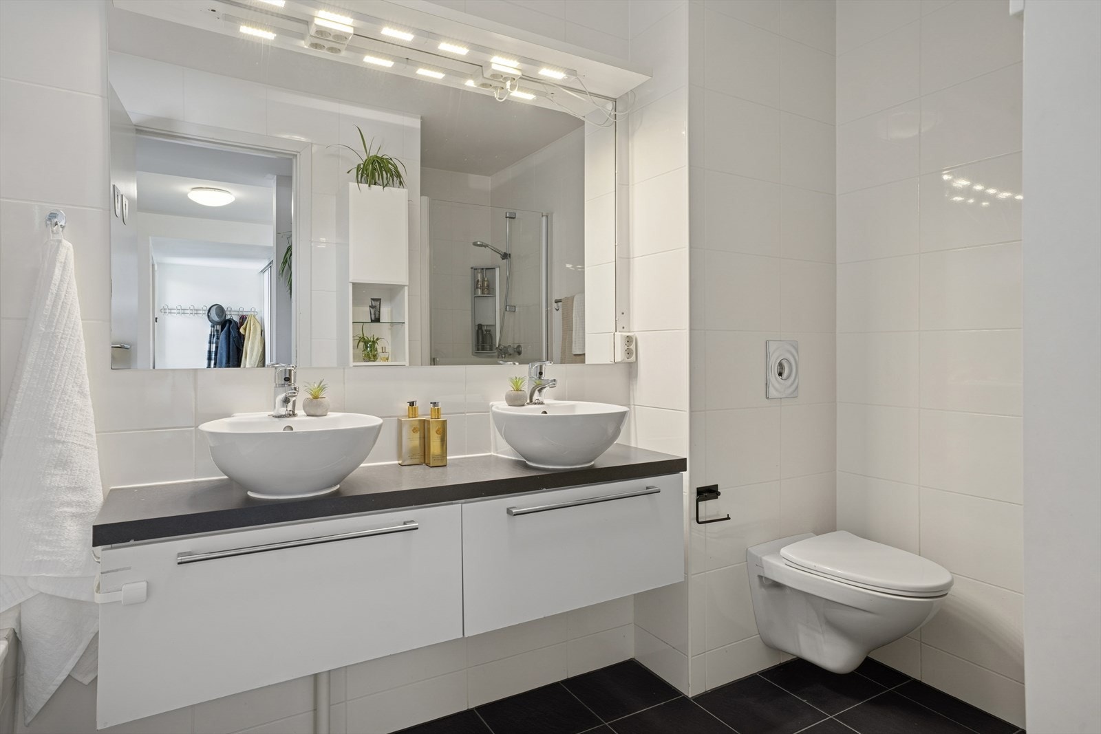 Lyst og pent bad med flislagte overflater. Her er det også dobbel servant, som er en liten hverdagsluksus Galleribilde