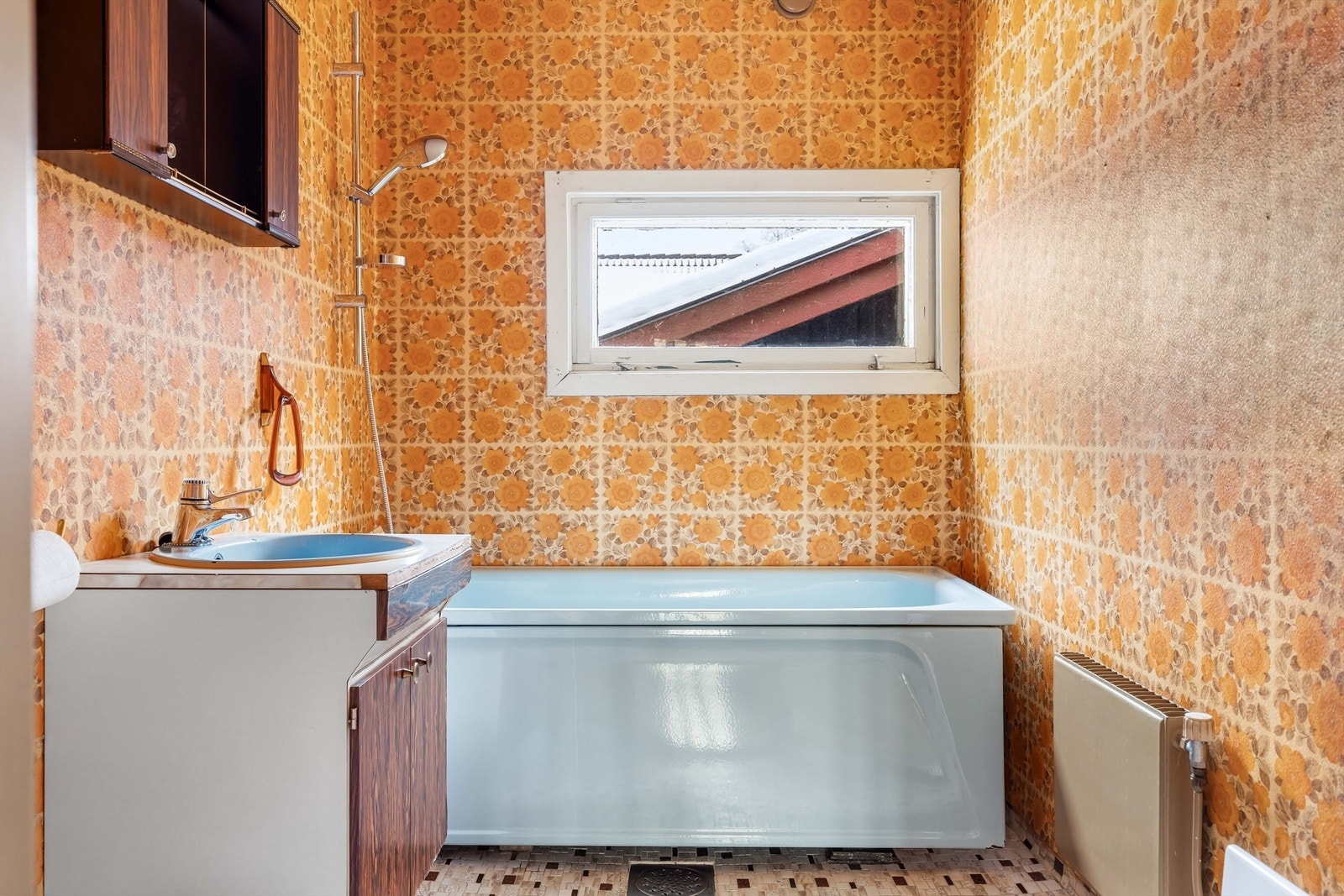 Badet har flislagt gulv og tapetserte veggflater. Galleribilde