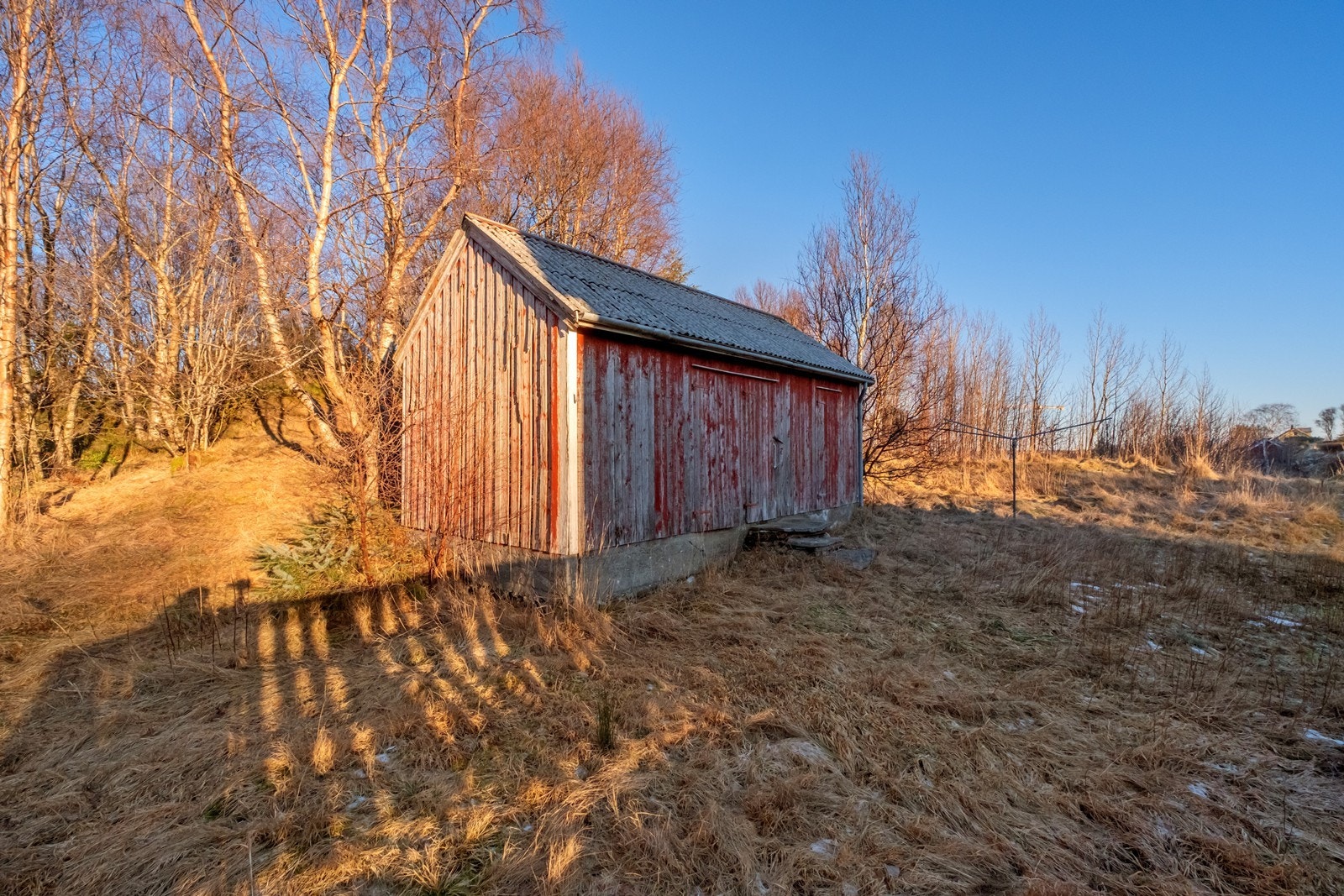 Vedboden har en enkel konstruksjon med stående kledning og bølgeplater på taket. Galleribilde