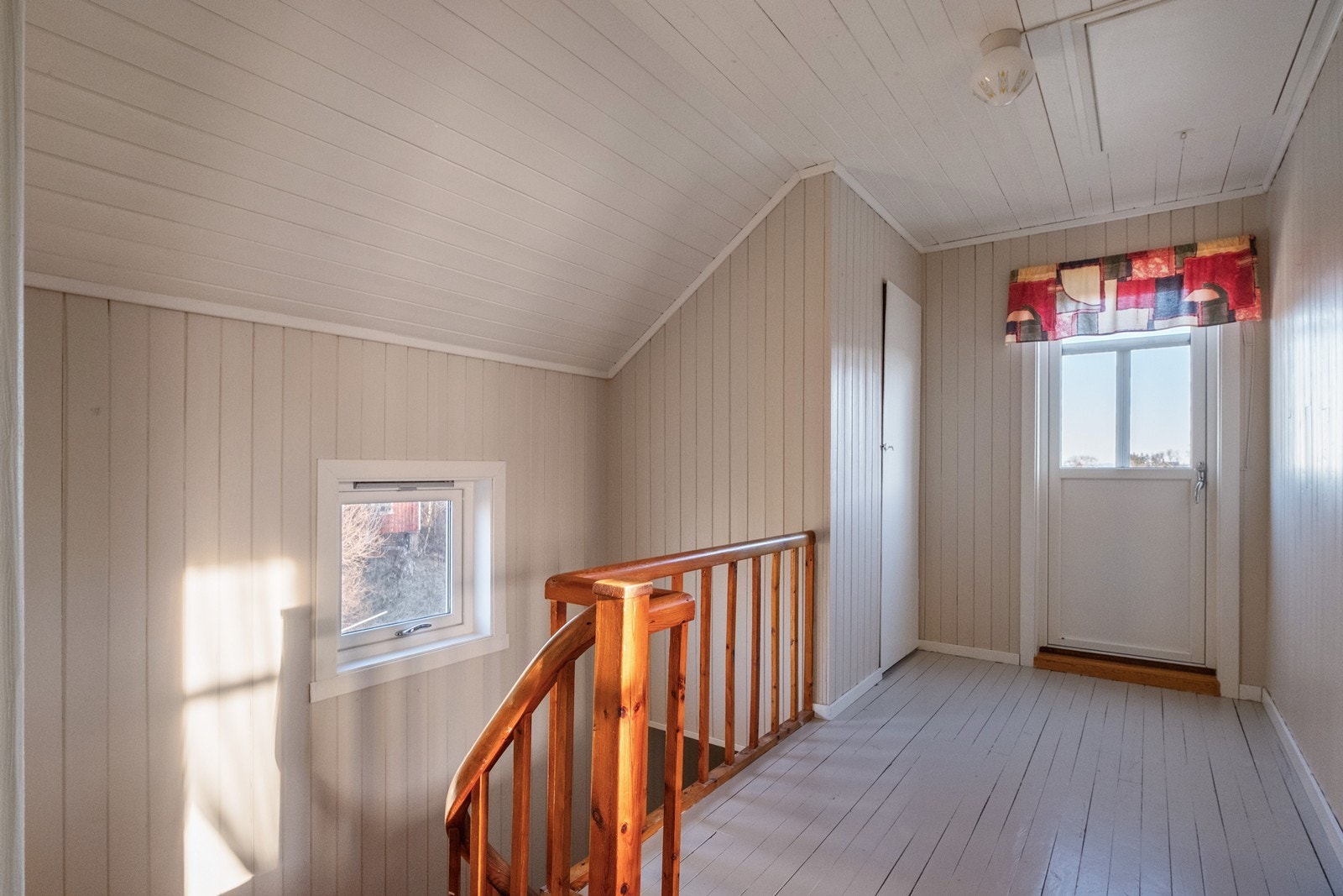 Loftsgang, med trapp til hovedetasjen, dør til kott og utgang til balkong. Luke i tak til mørkeloft. Galleribilde