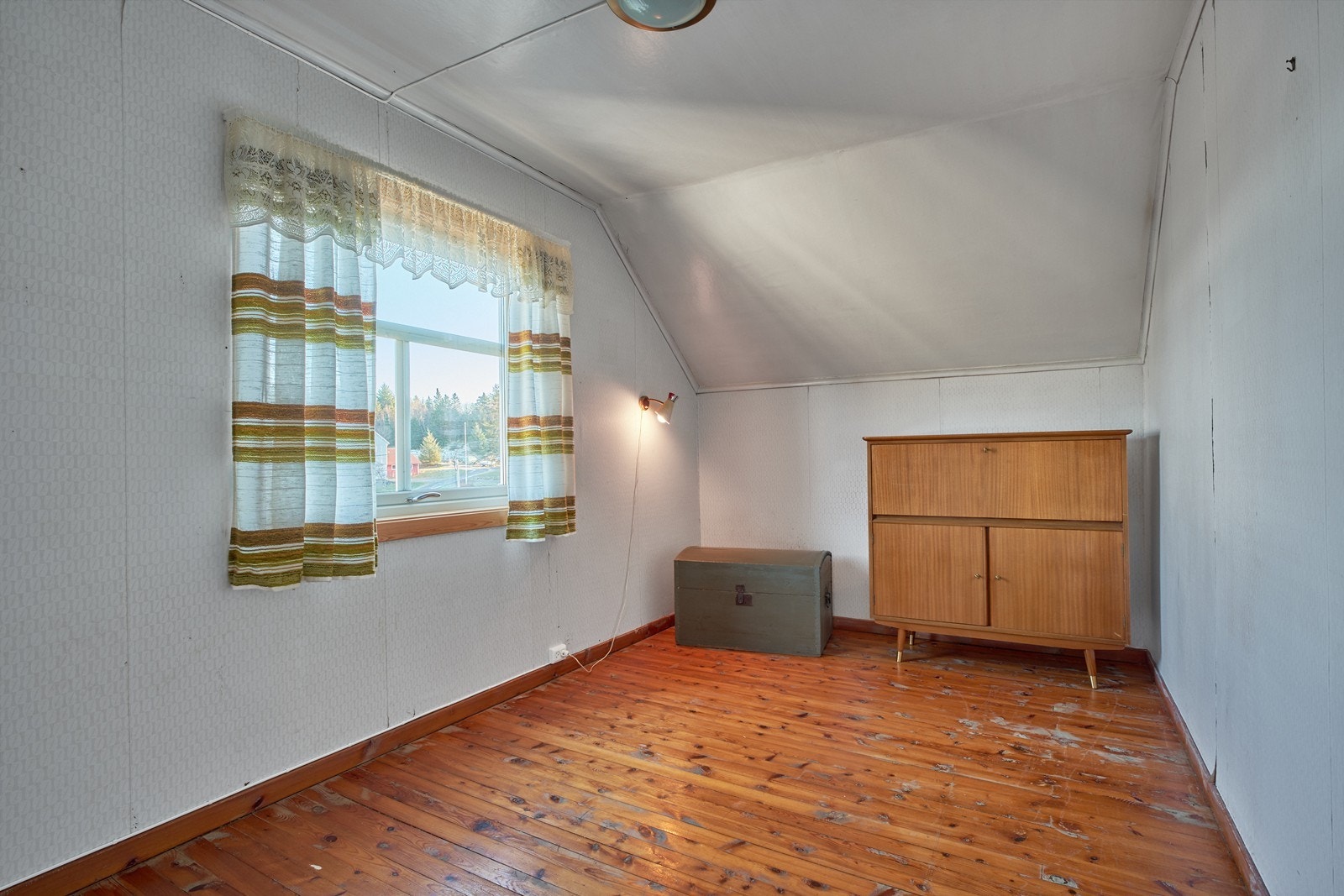 Et av boligens tre soverom, med skråtak og originalt tregulv. Galleribilde