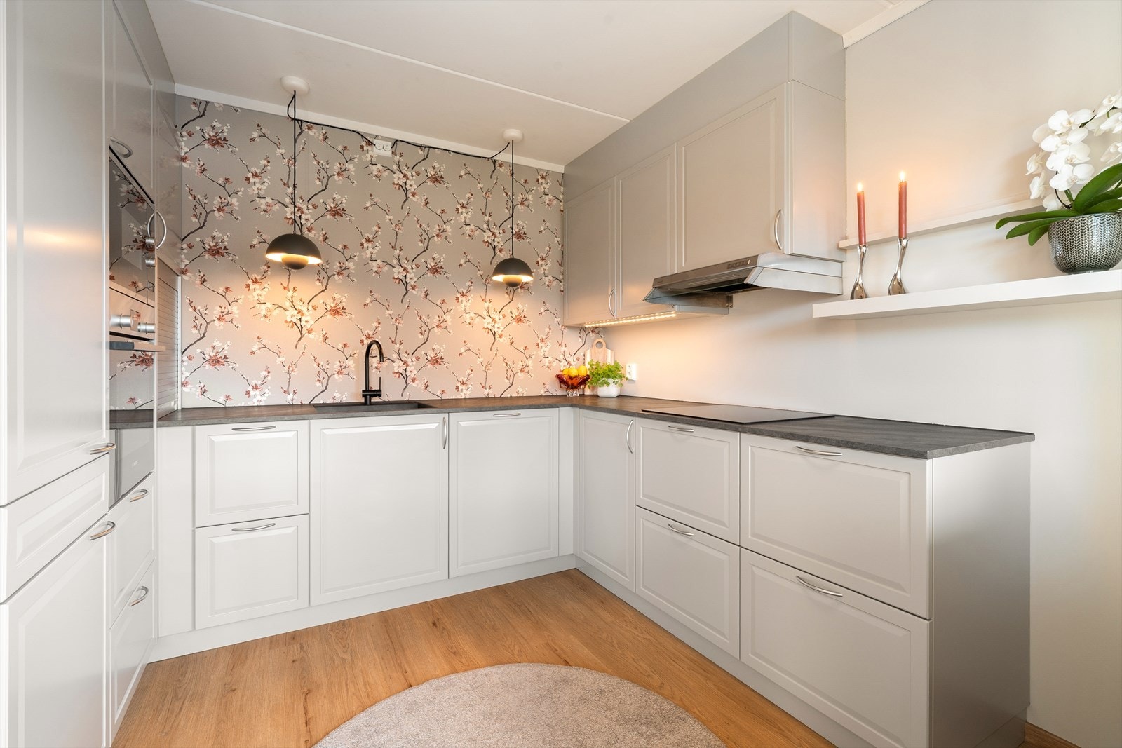 Kjøkkeninnrednng med profilerte glatte fronter, laminert benkeplate og kompesitt oppvaskkum. Det er integrert kjøle/fryseskap, oppvaskmaskin, stekeovn, mikrobølgeovn og keramisk koketopp. Galleribilde