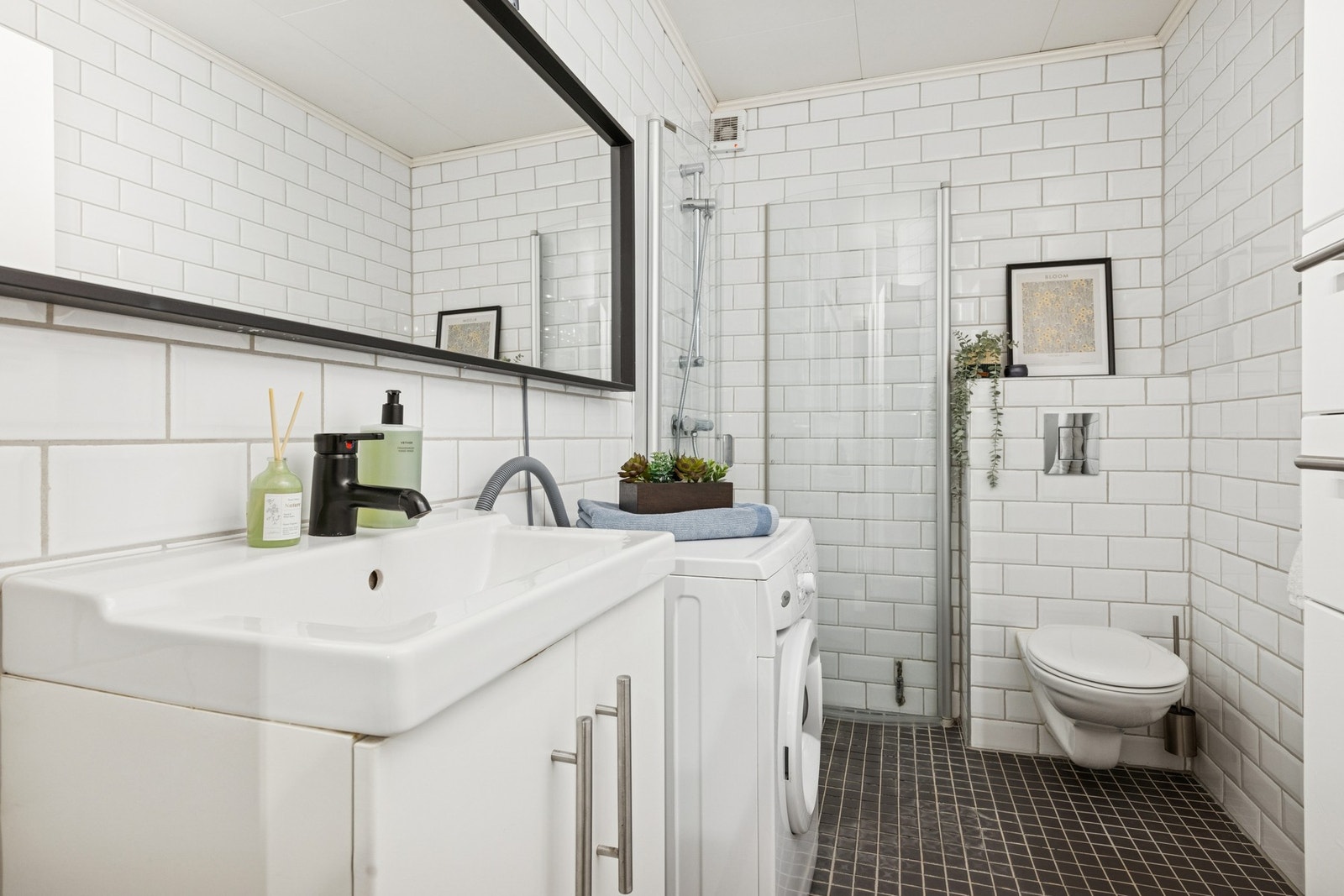 Innredet med dusjhjørne, og servant montert på underskap og speilskap. Vegghengt toalett. Galleribilde