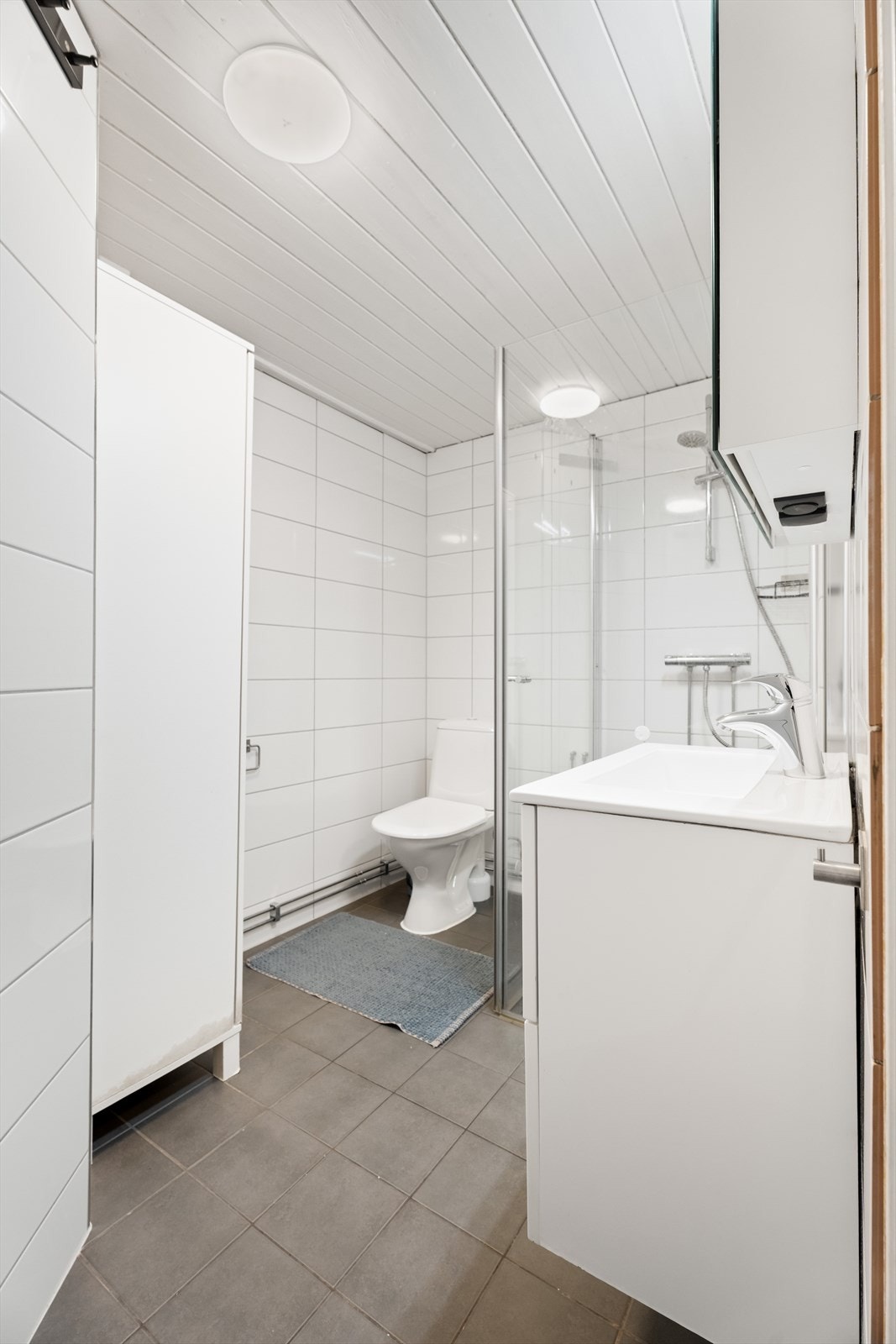 Badet er innredet med dusjhjørne, toalett, servant og skap. Galleribilde