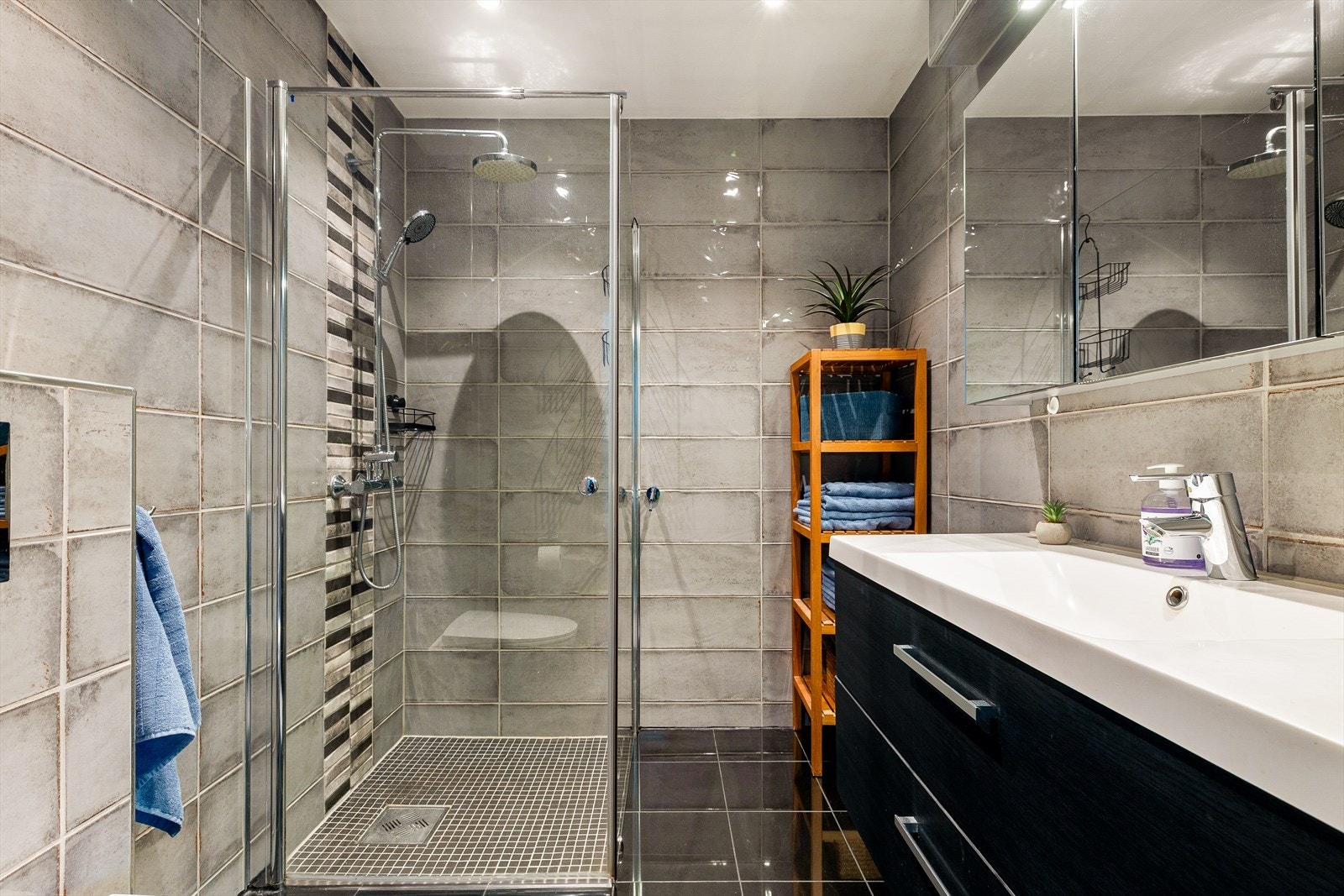 Delikat og moderne bad med flislagte overflater, romslig dusjhjørne og praktisk innredning med god oppbevaringsplass. Et stilrent og funksjonelt rom som gir en behagelig hverdagskomfort. Galleribilde