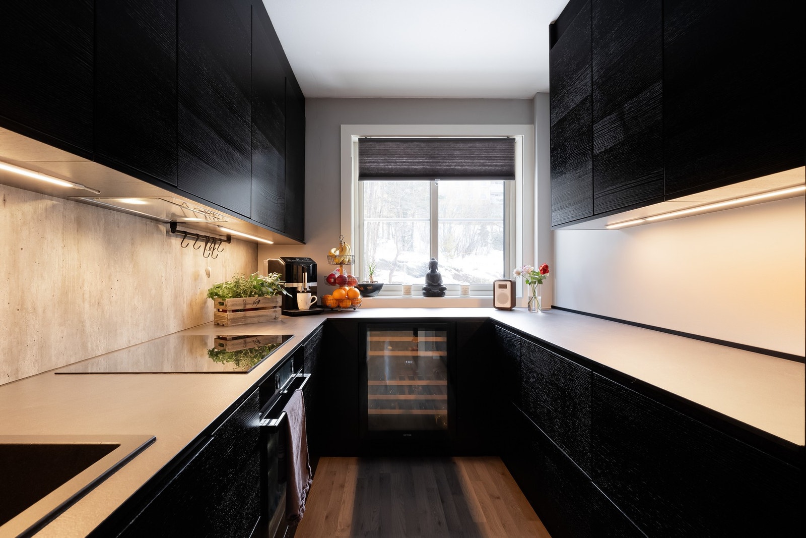 Kjøkkeninnredningen fra Epoq har slette fronter i sort og benkeplate i laminat med nedfelt oppvaskkum. Galleribilde